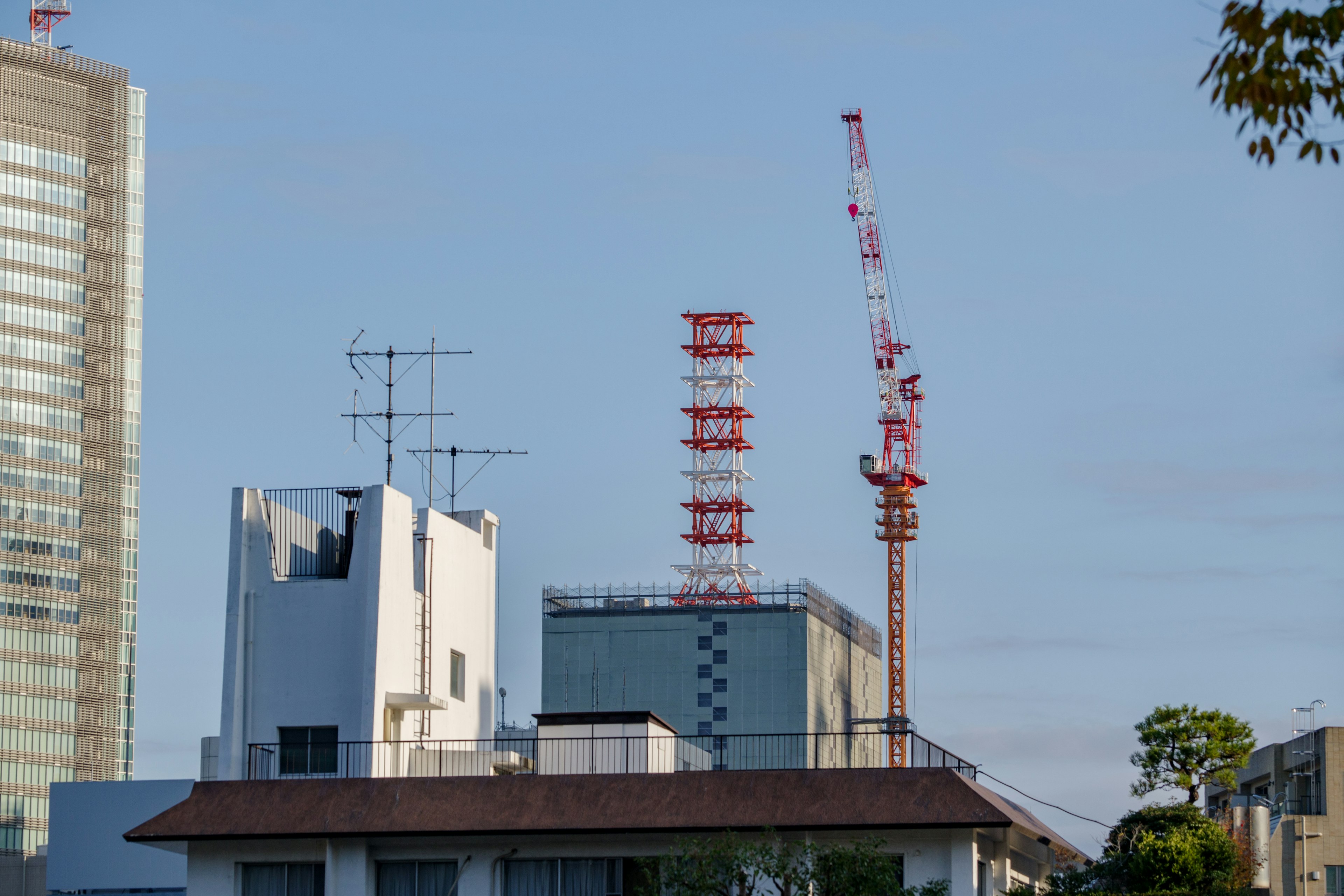 Stadtlandschaft mit Gebäuden und Baukränen vor blauem Himmel