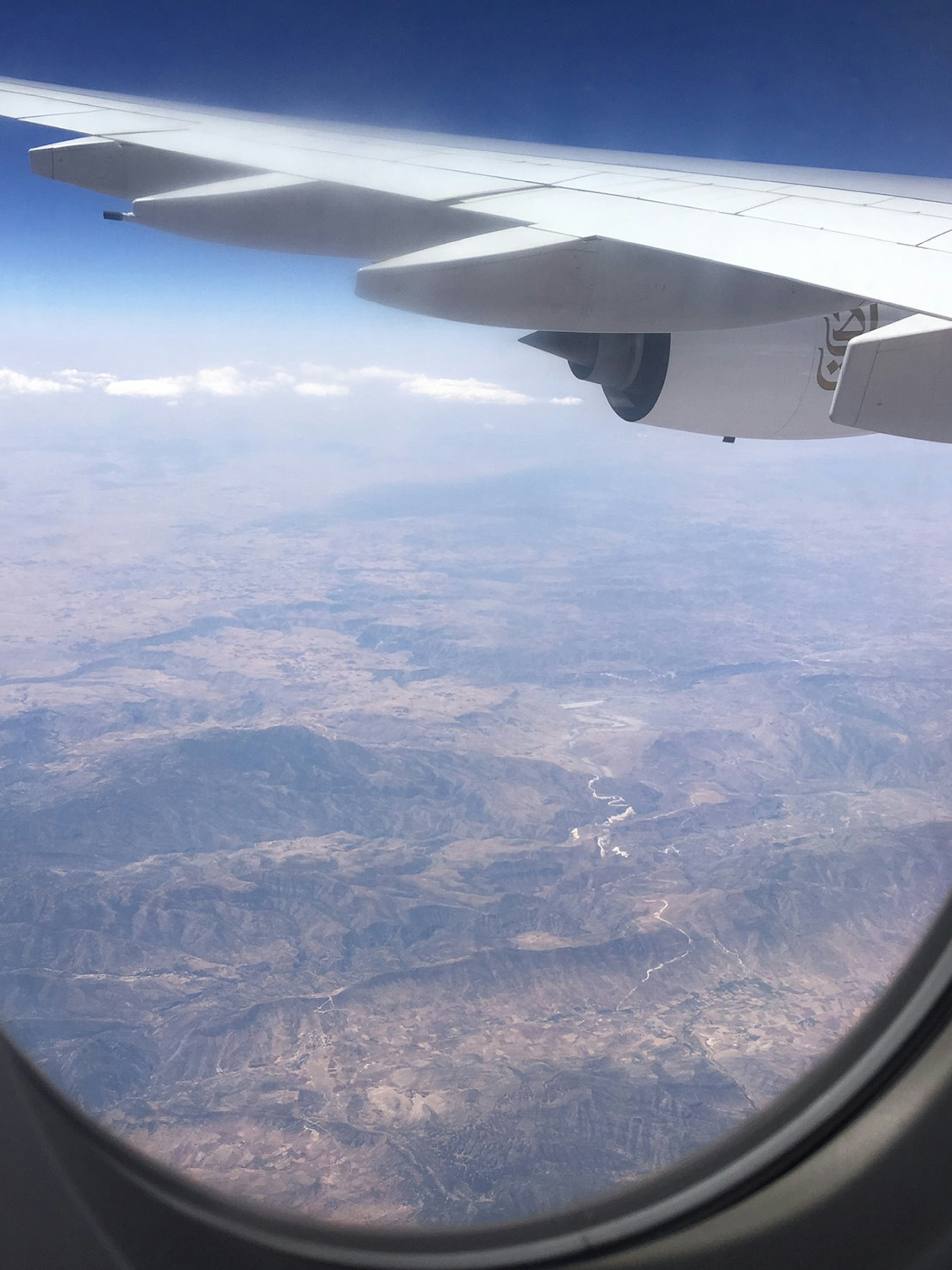 Blick auf Berge und weite Landschaften aus einem Flugzeugfenster