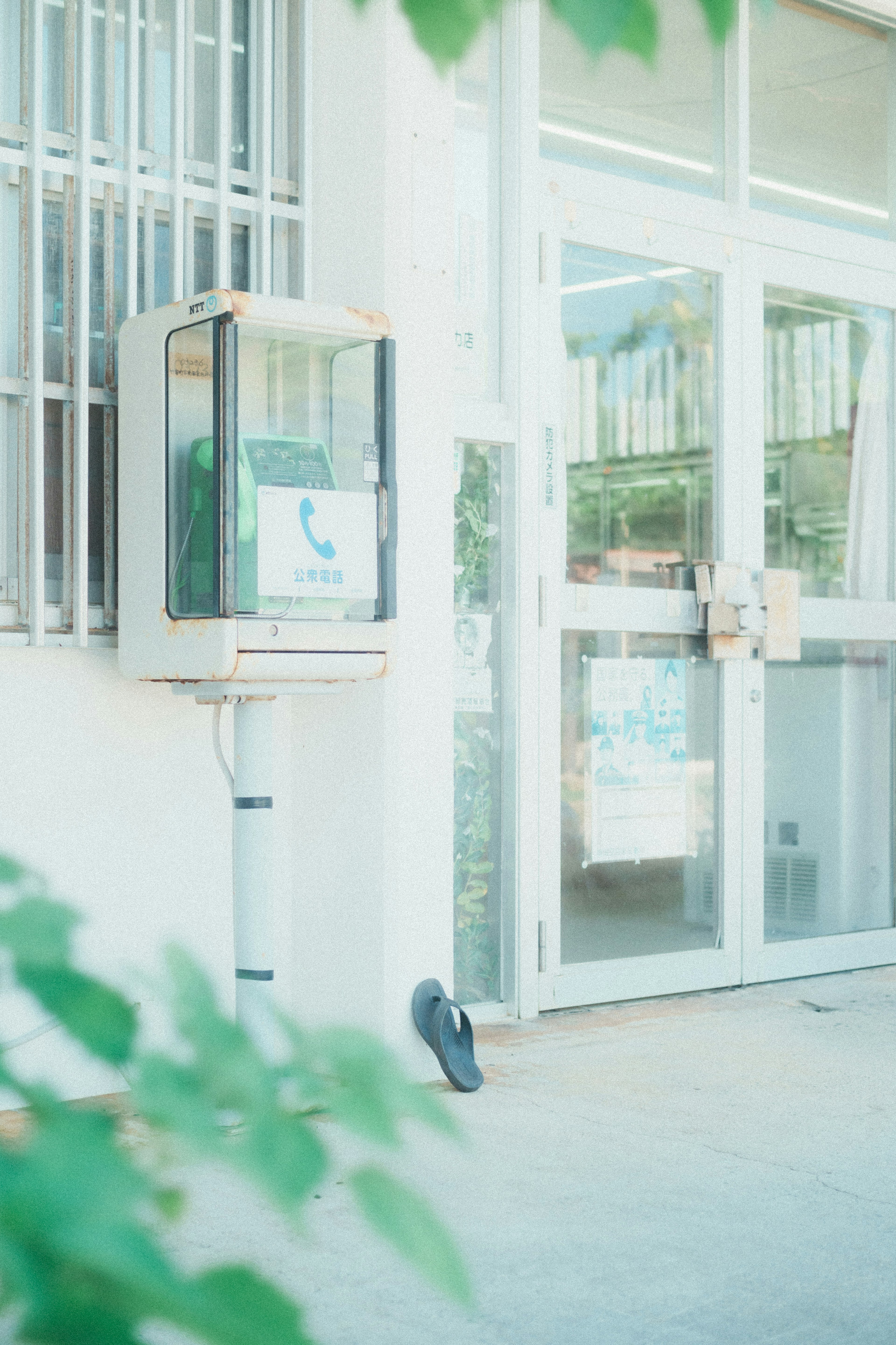 Telephone booth beside a glass door building