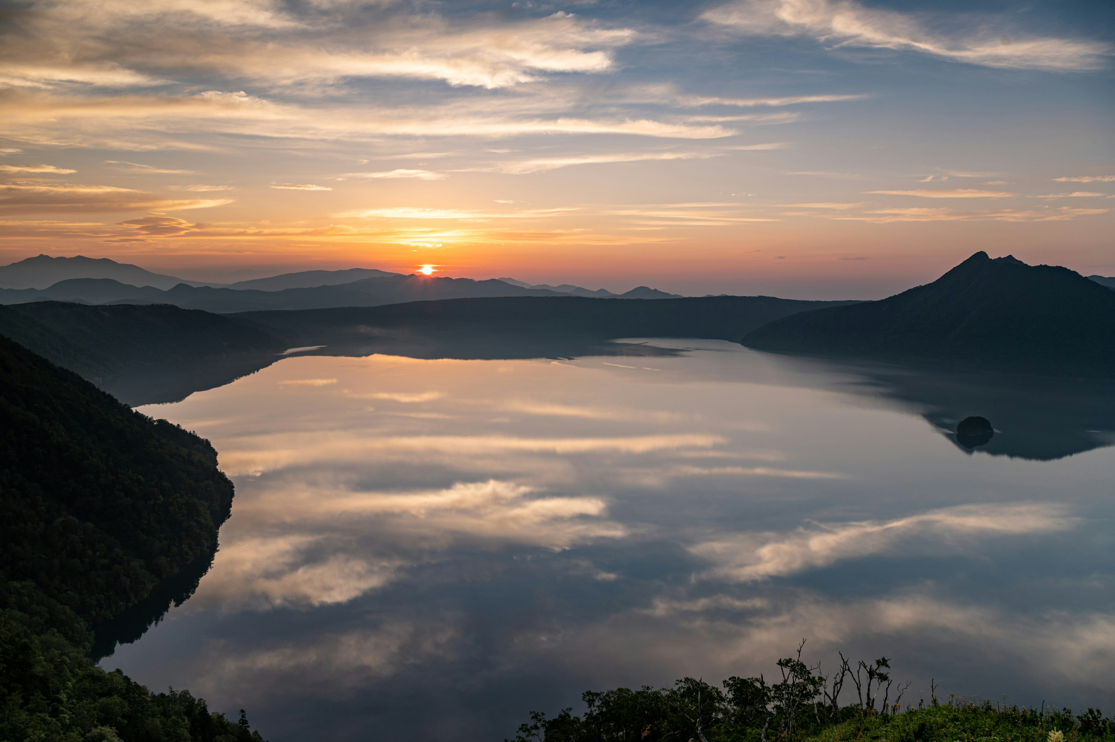 美しい湖の夕日と山々の風景