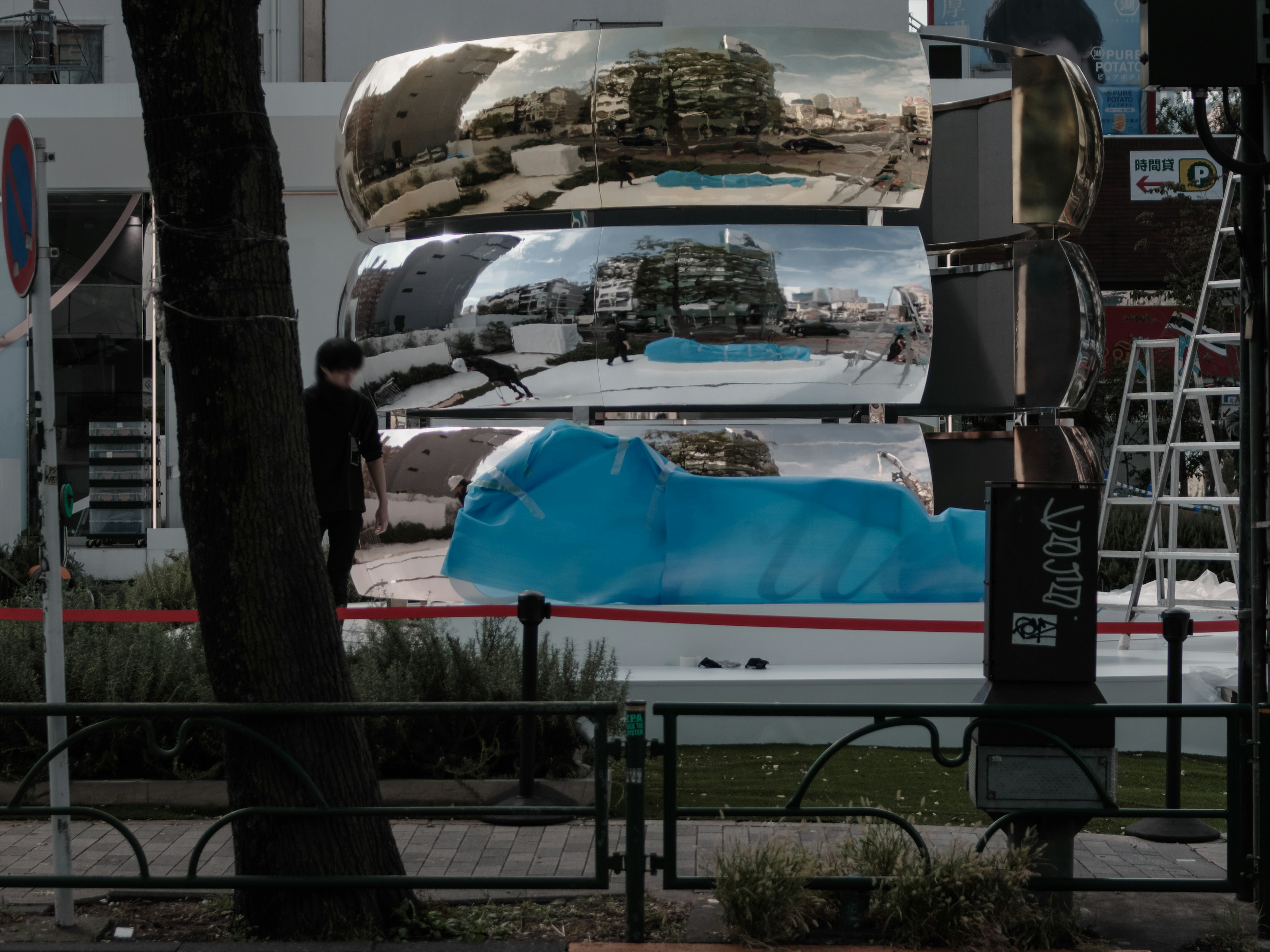 A landscape featuring a blue object and reflective metal structures