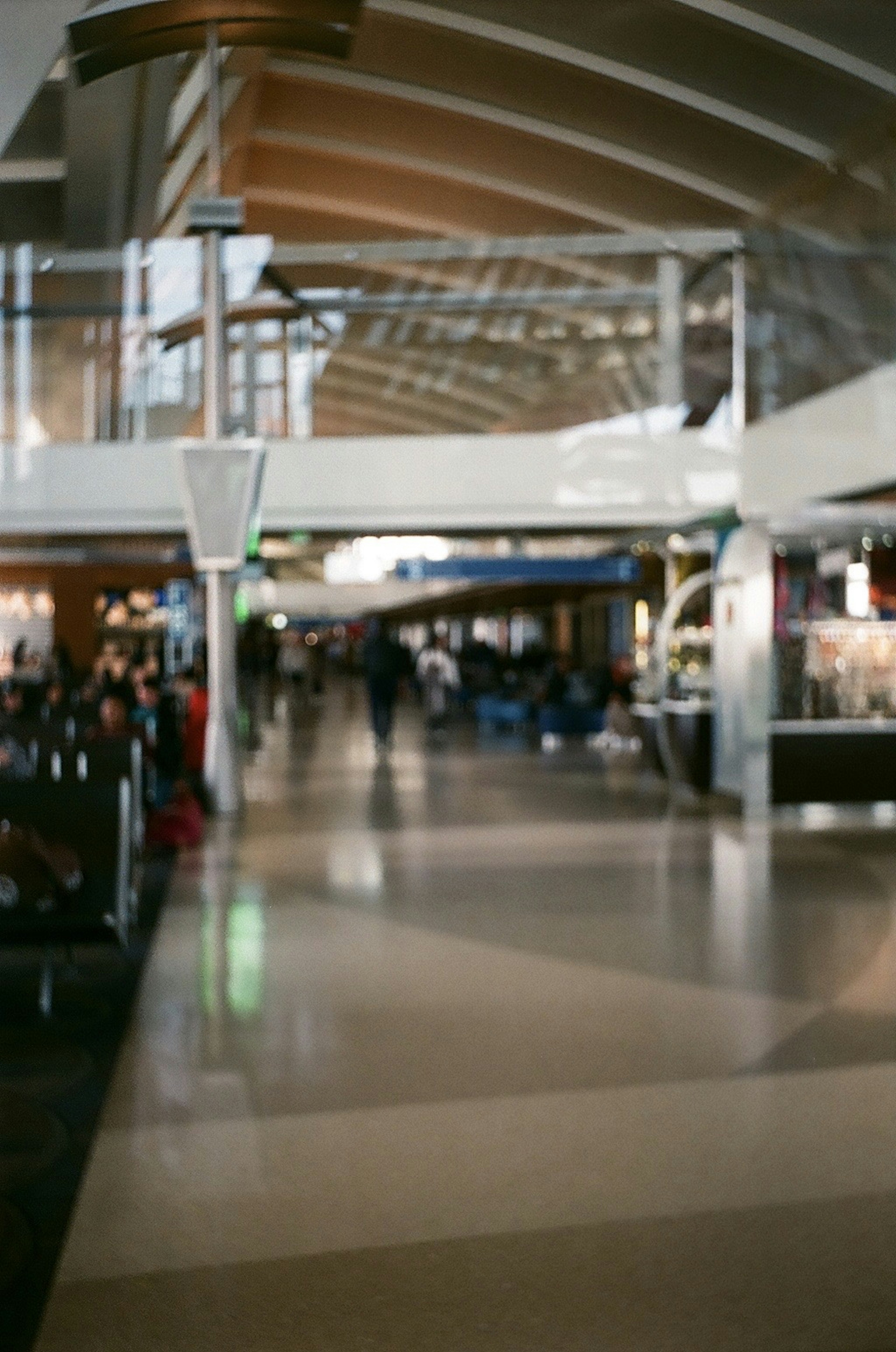 Vista interna di un aeroporto con persone che camminano in un'area spaziosa