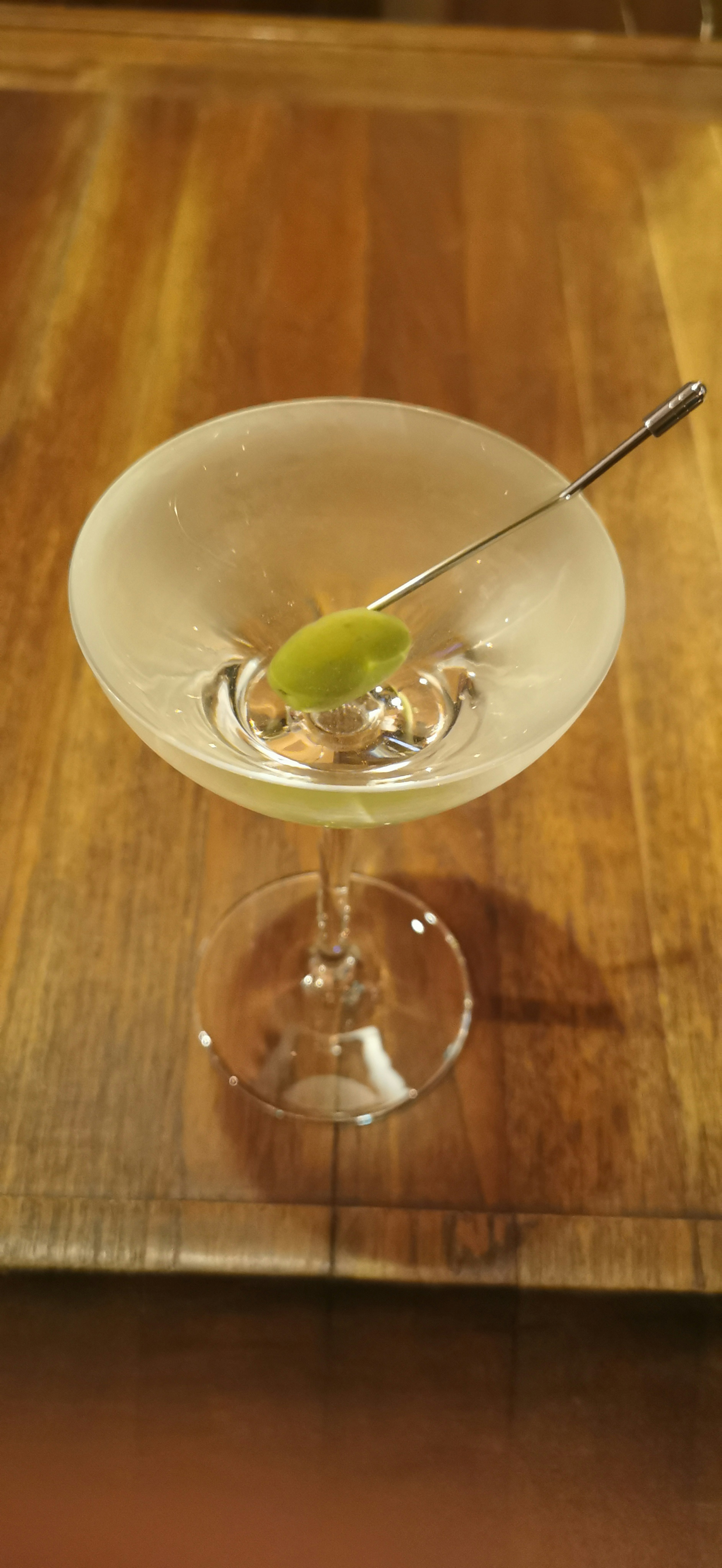 Bicchiere da cocktail con una bevanda e un'oliva come guarnizione