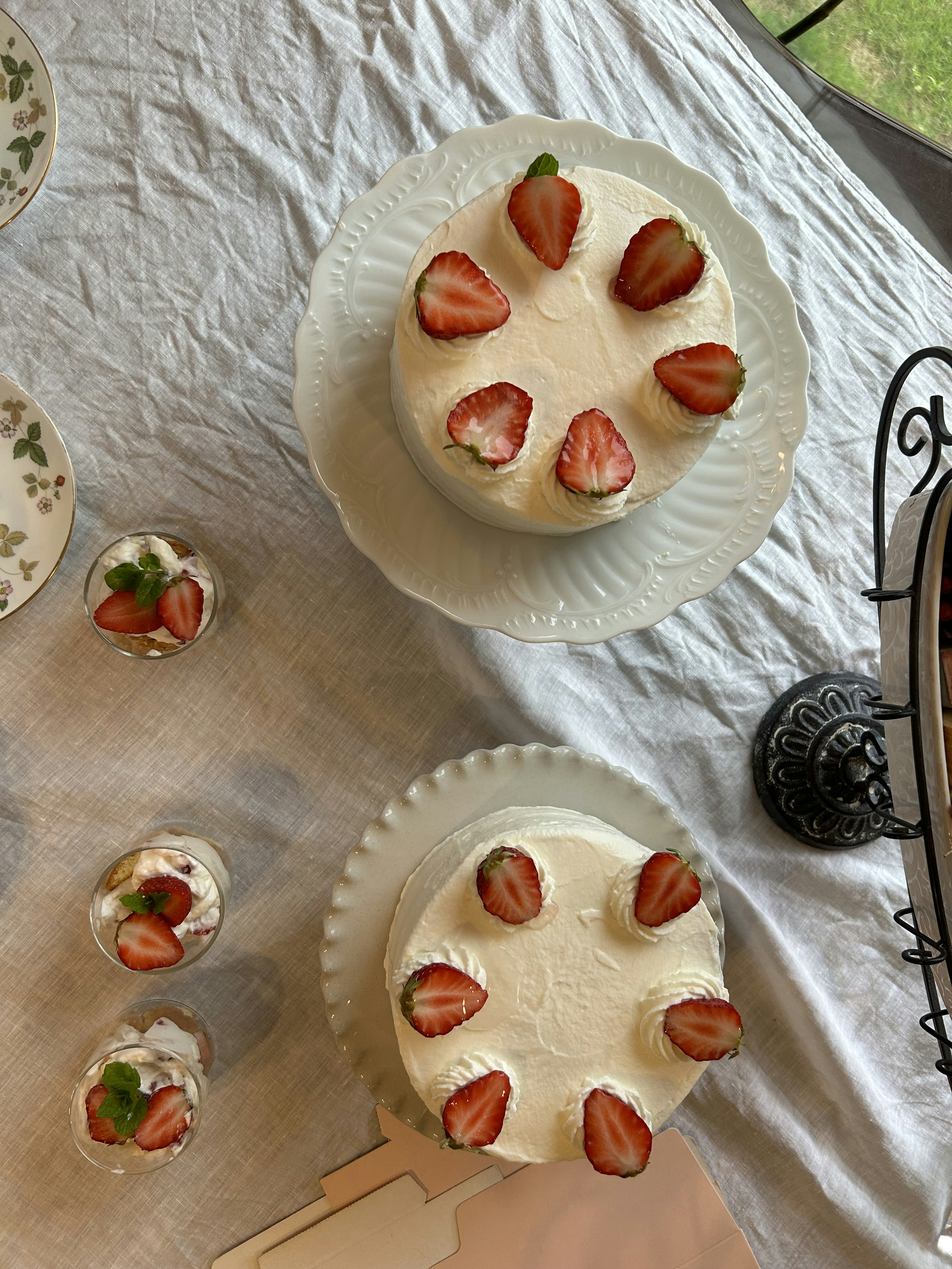 Dos pasteles redondos decorados con fresas sobre un mantel blanco