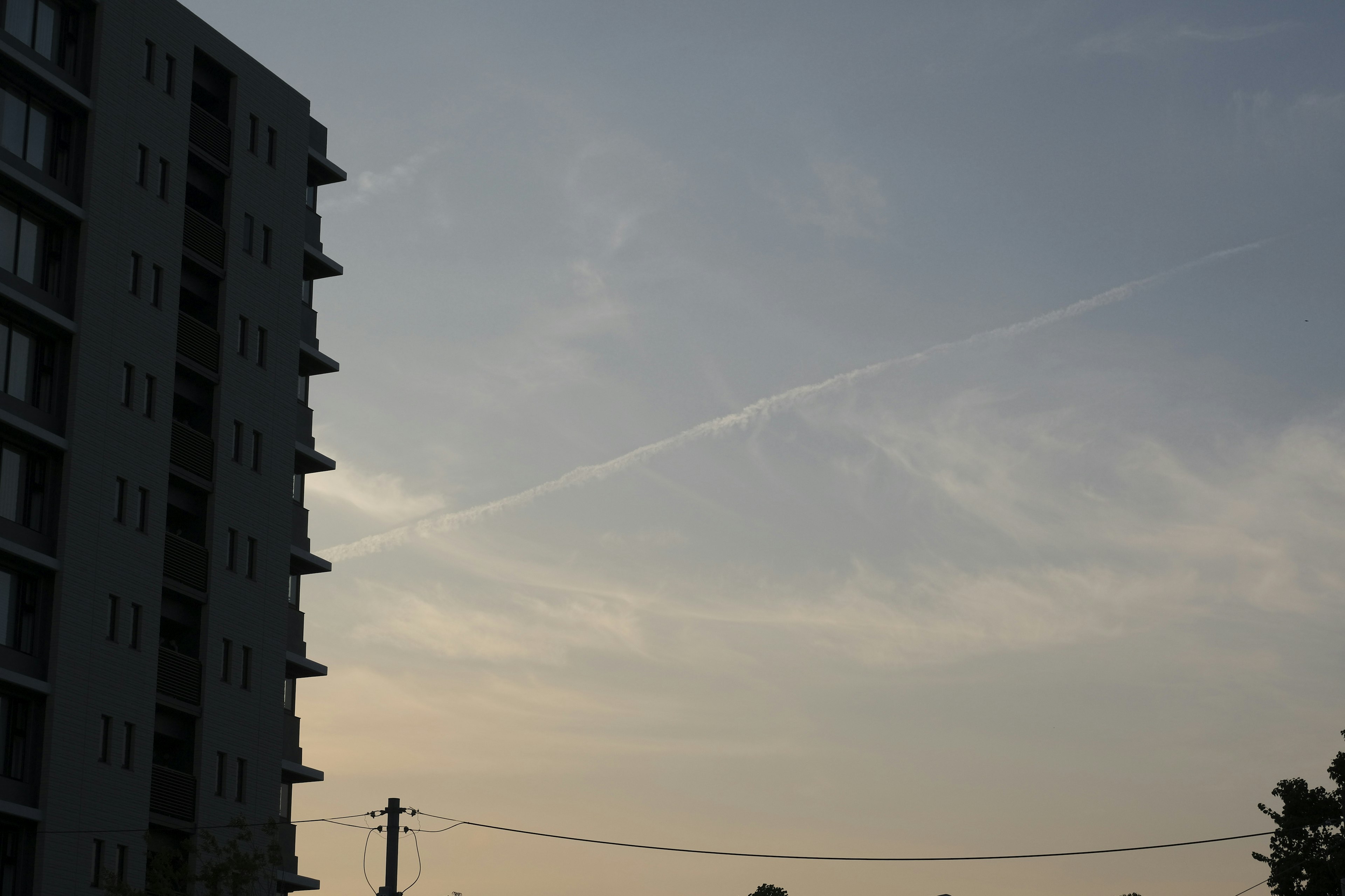 Silhouette eines hohen Gebäudes gegen einen blauen Himmel mit Wolken