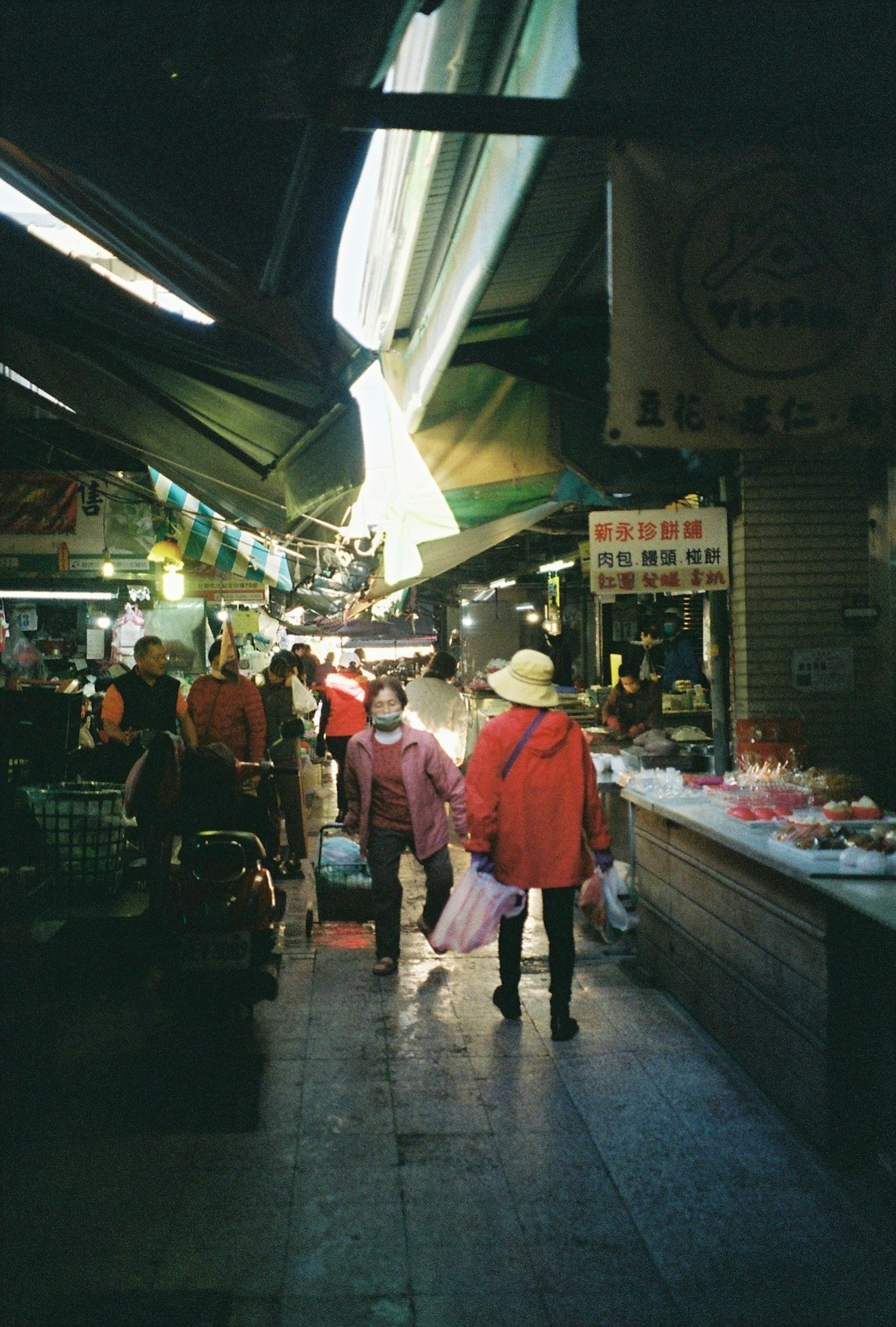 People walking in a market street with bright light