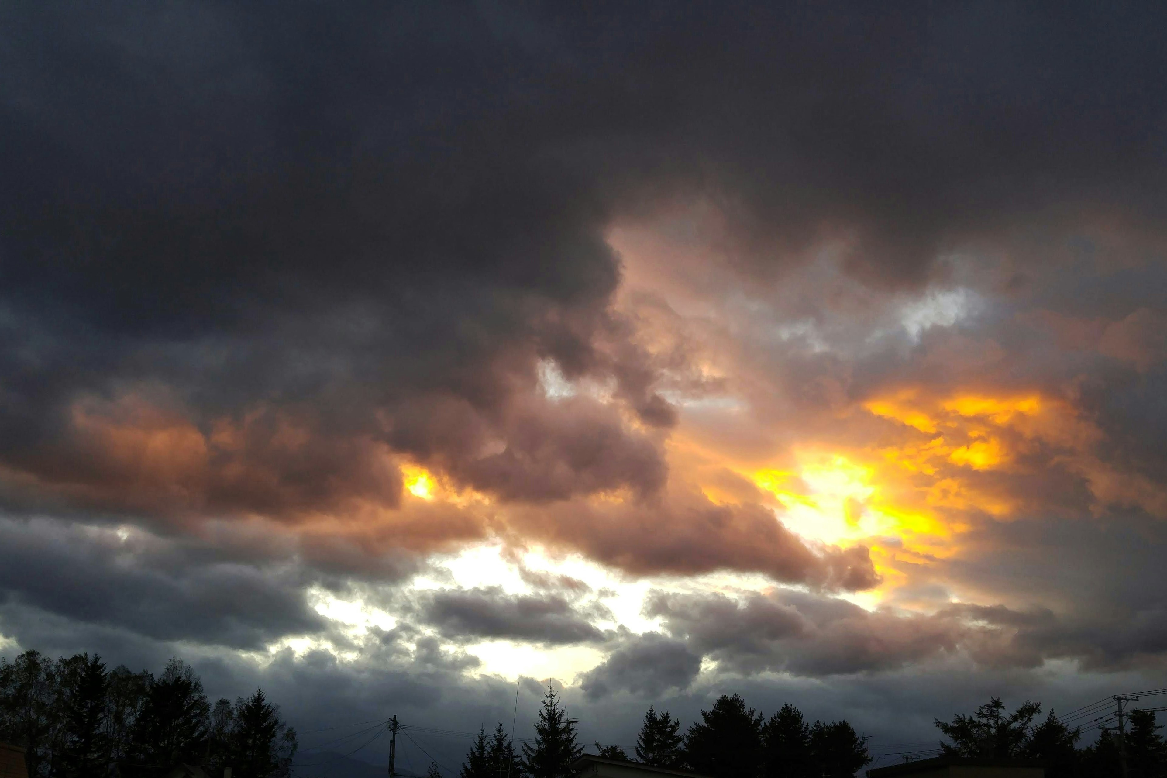 Tramonto drammatico con nuvole arancioni e grigie nel cielo