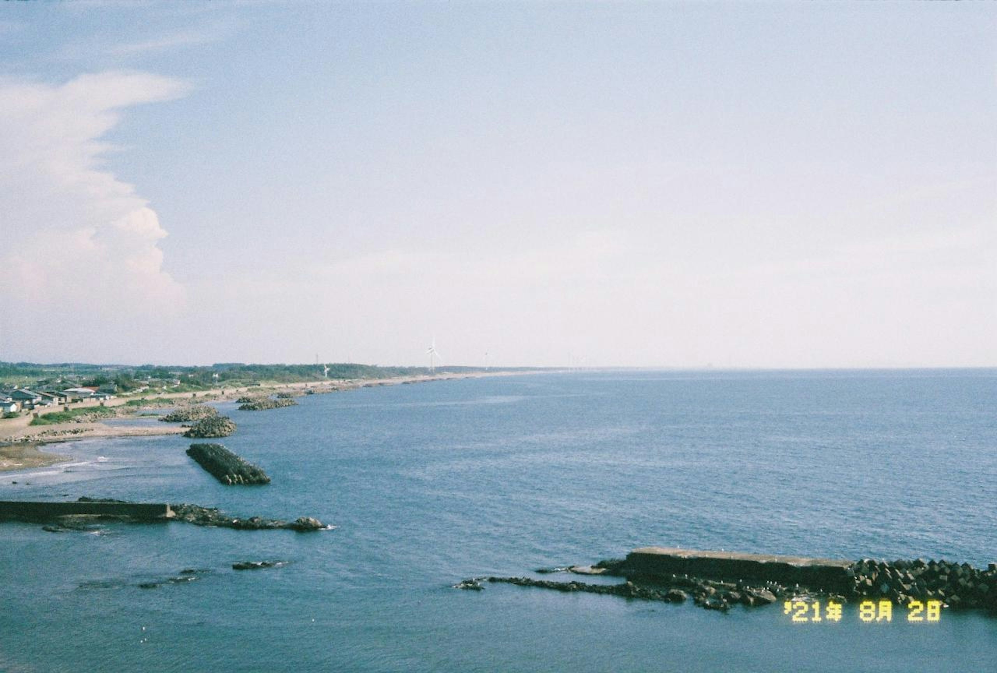 青い海と空が広がる風景 海岸線と防波堤が見える