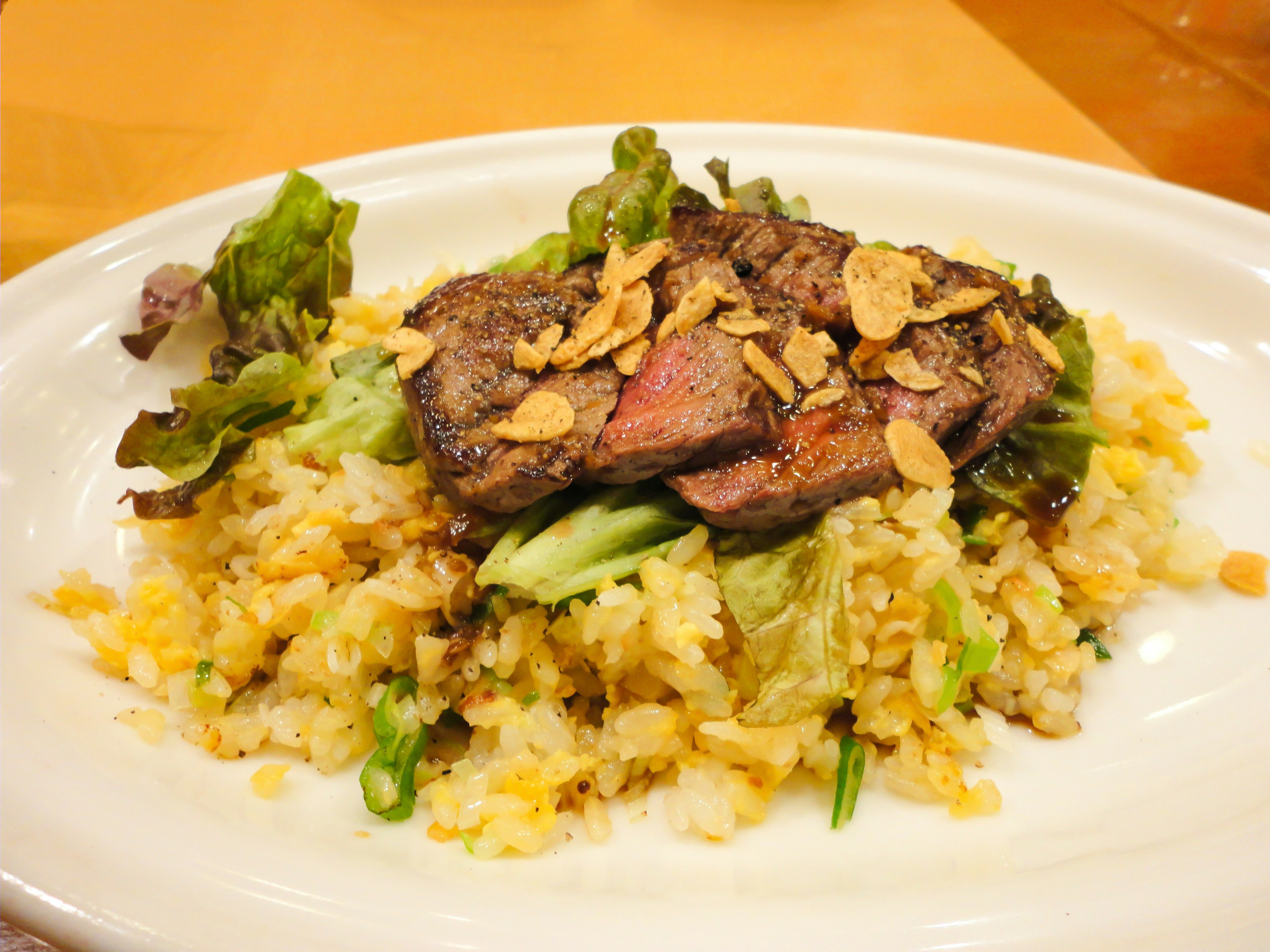 Hidangan daging panggang di atas nasi dengan sayuran