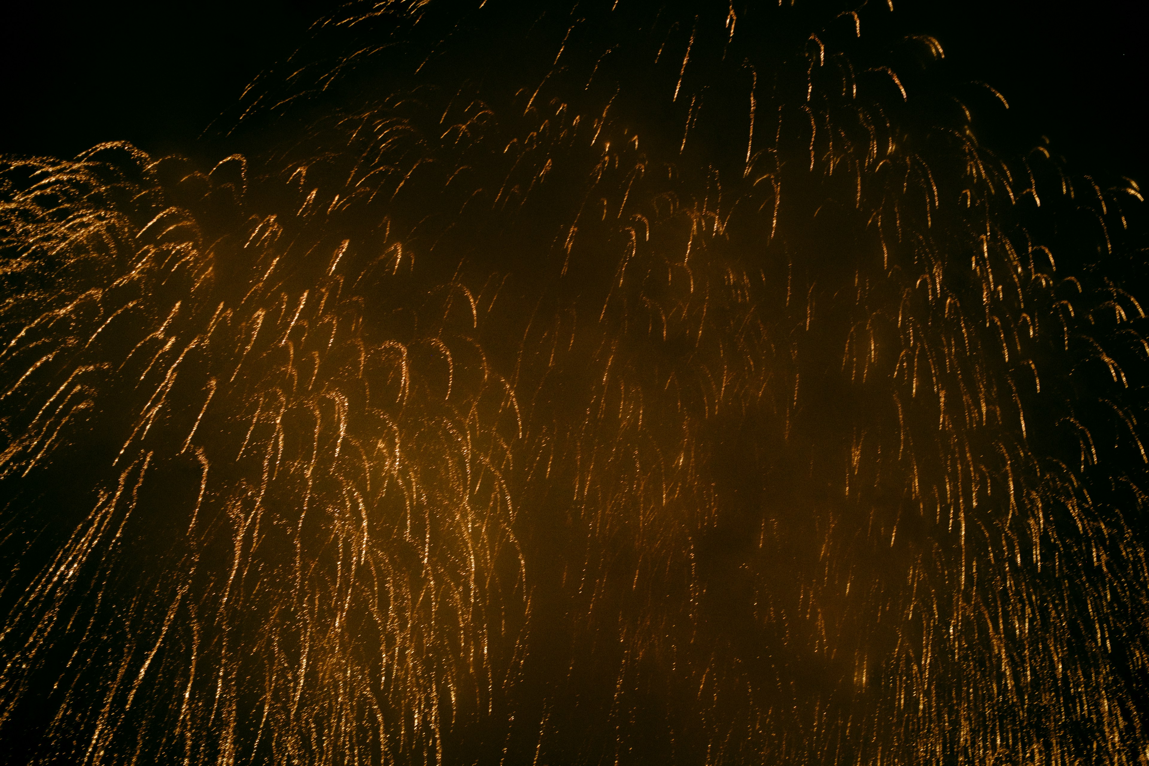 Golden sparks scattering against a dark background