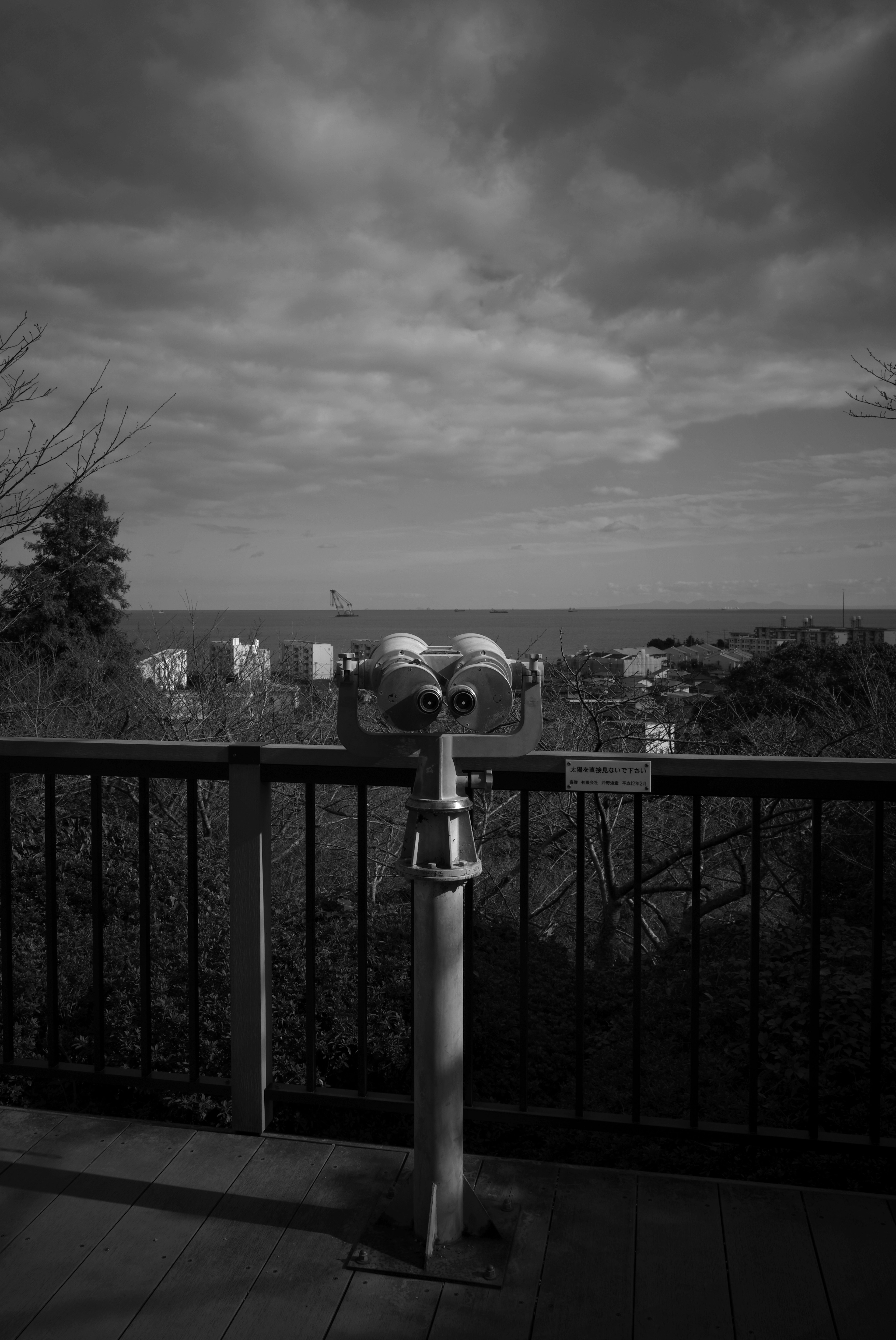 Viewing binoculars overlooking the sea with a cloudy sky