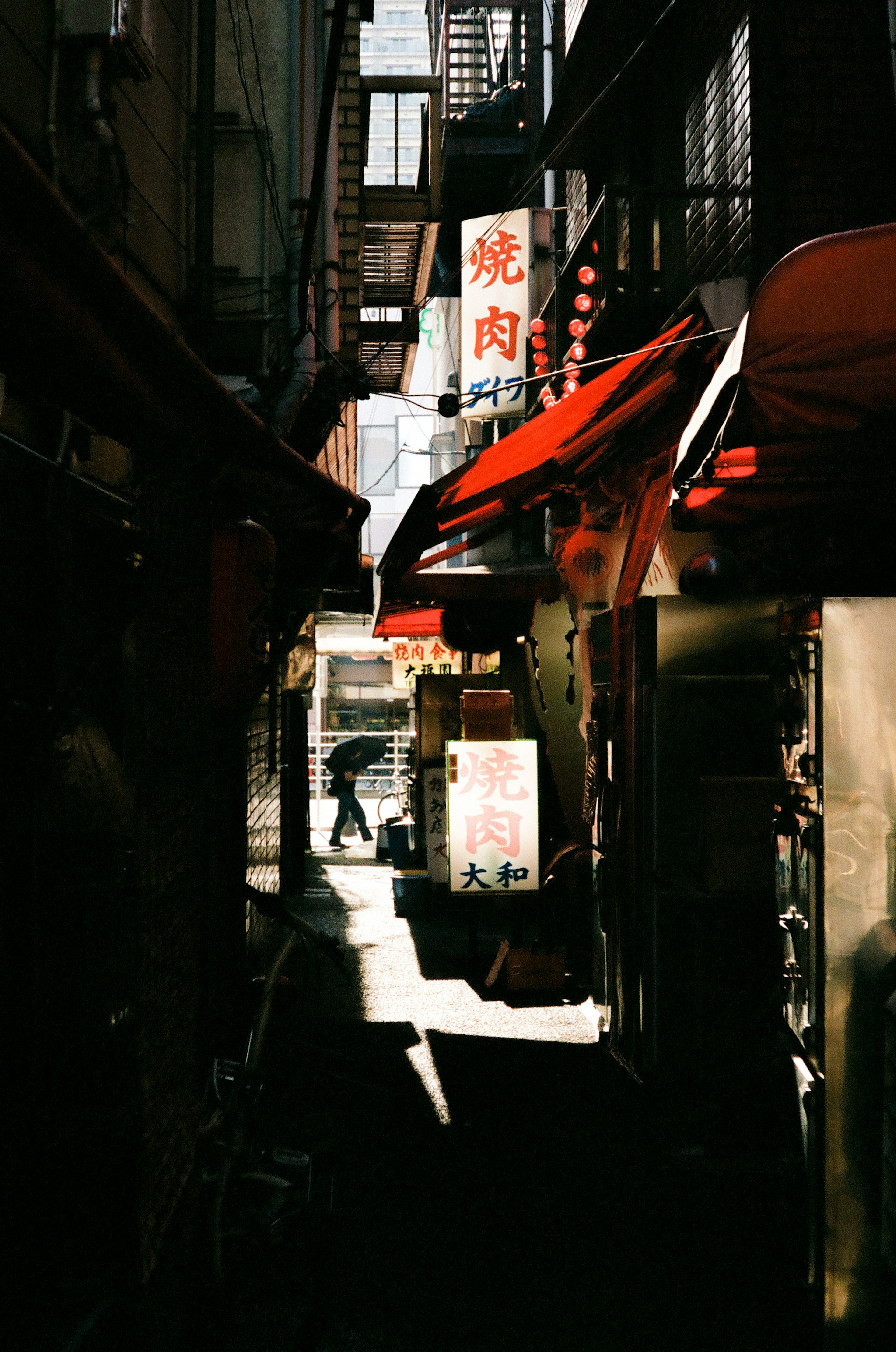 狭い路地に赤いテントの屋台が並ぶ風景