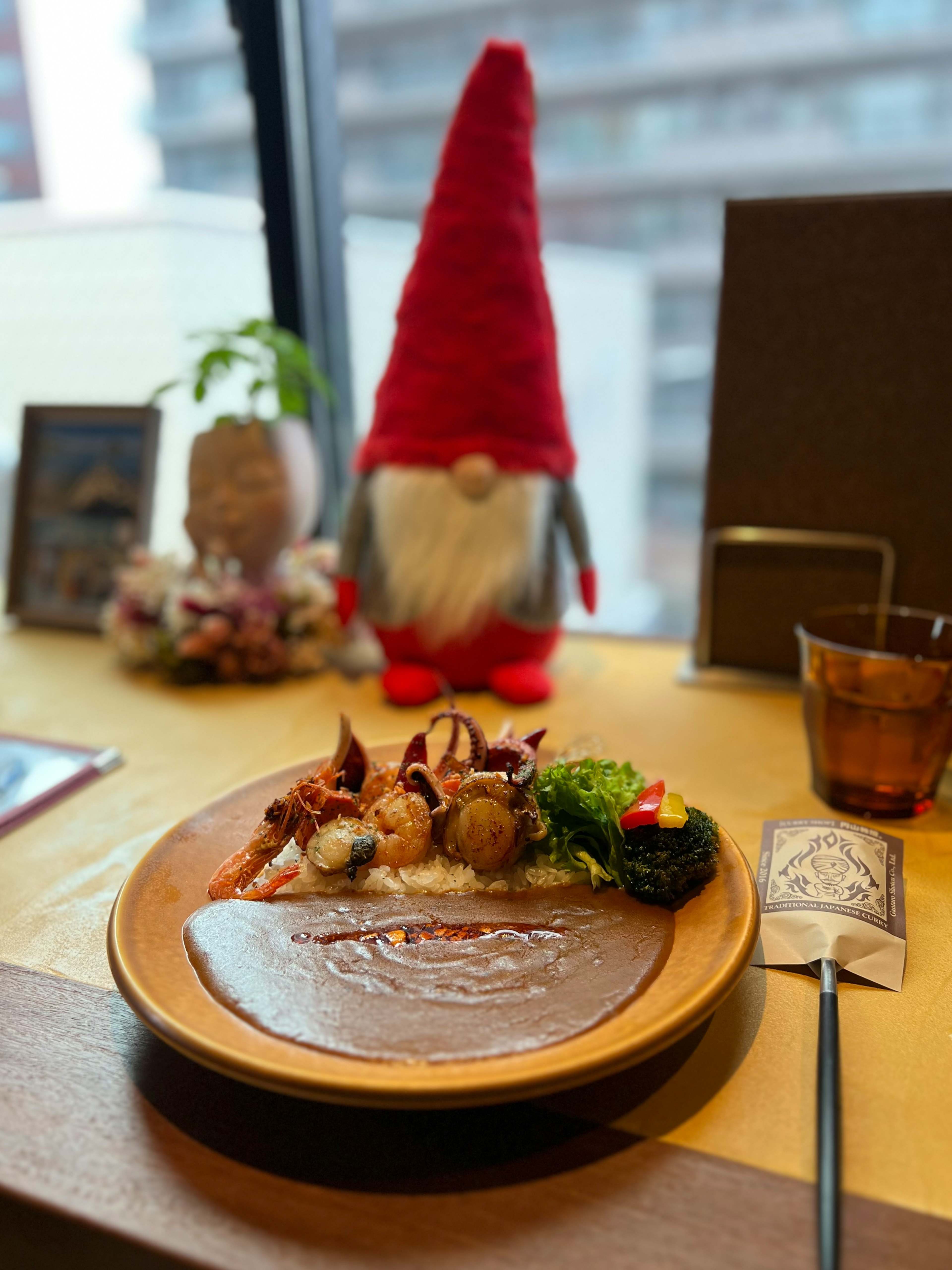 Delicious meal served on a wooden plate with a red gnome decoration in the background