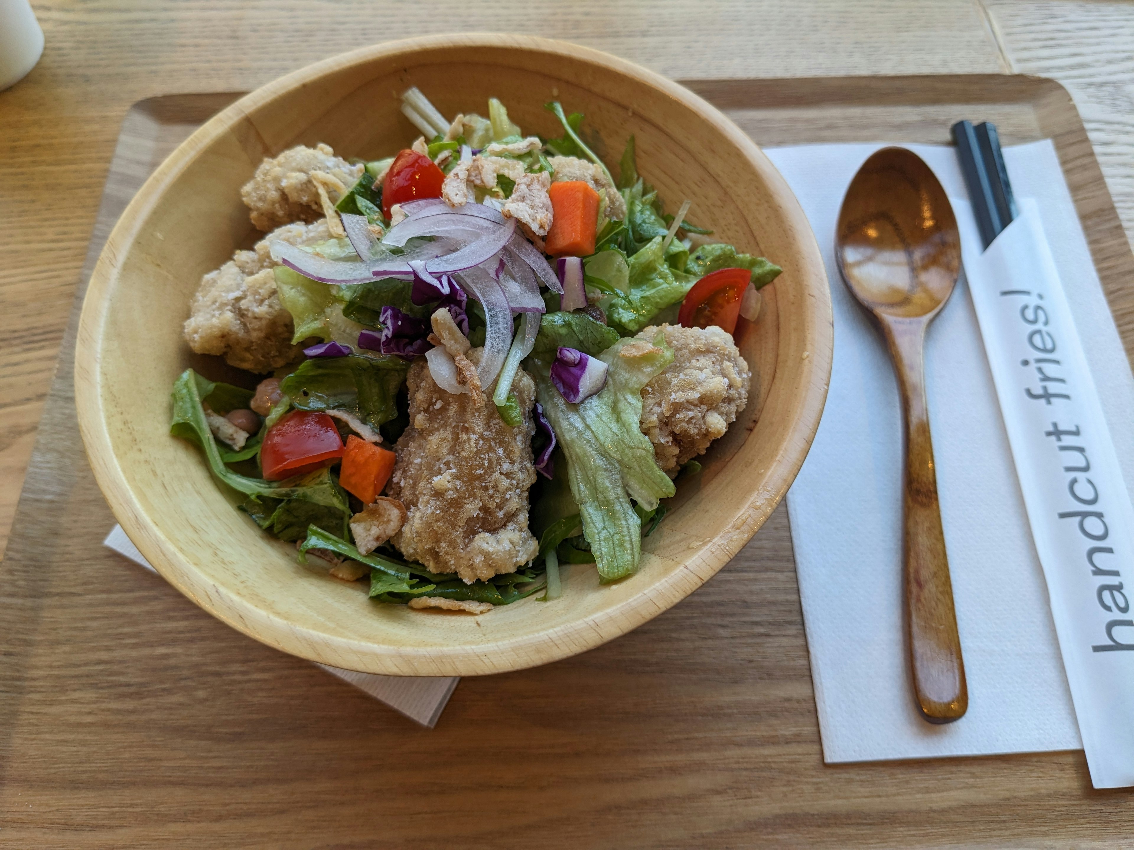 A salad bowl featuring crispy chicken pieces and fresh vegetables