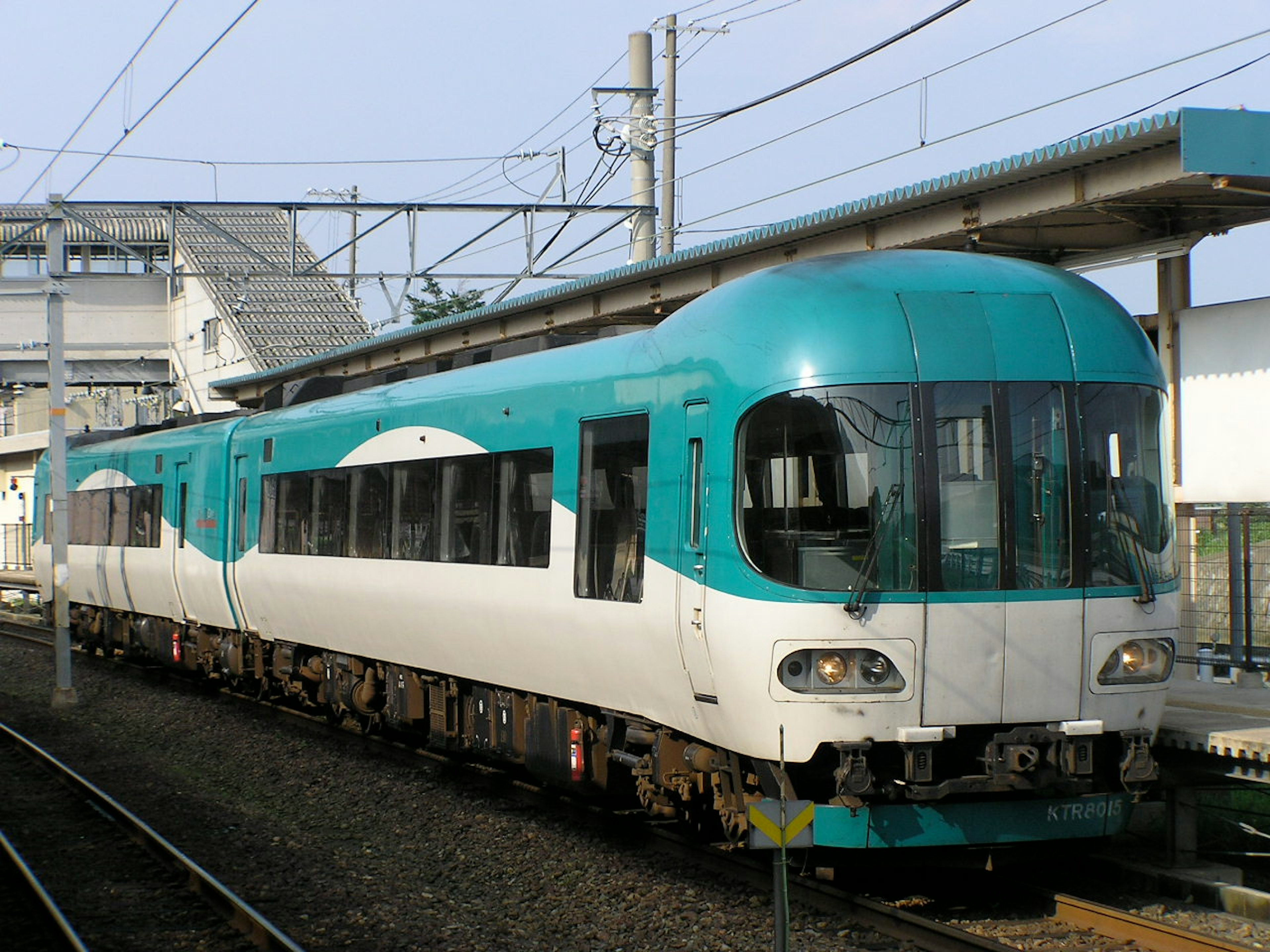 青と白のデザインの列車が駅に停車している