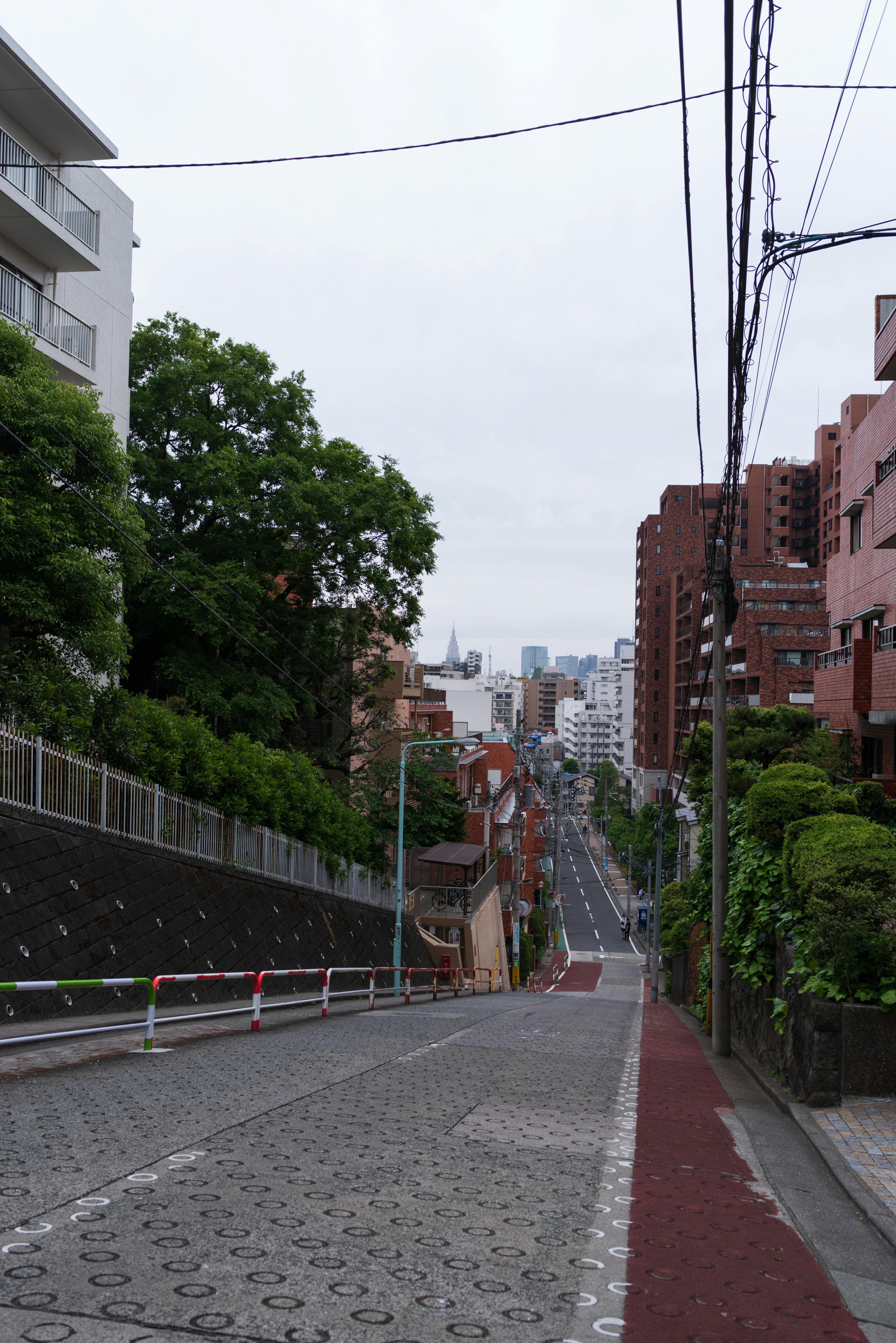 Steep street with surrounding buildings and greenery