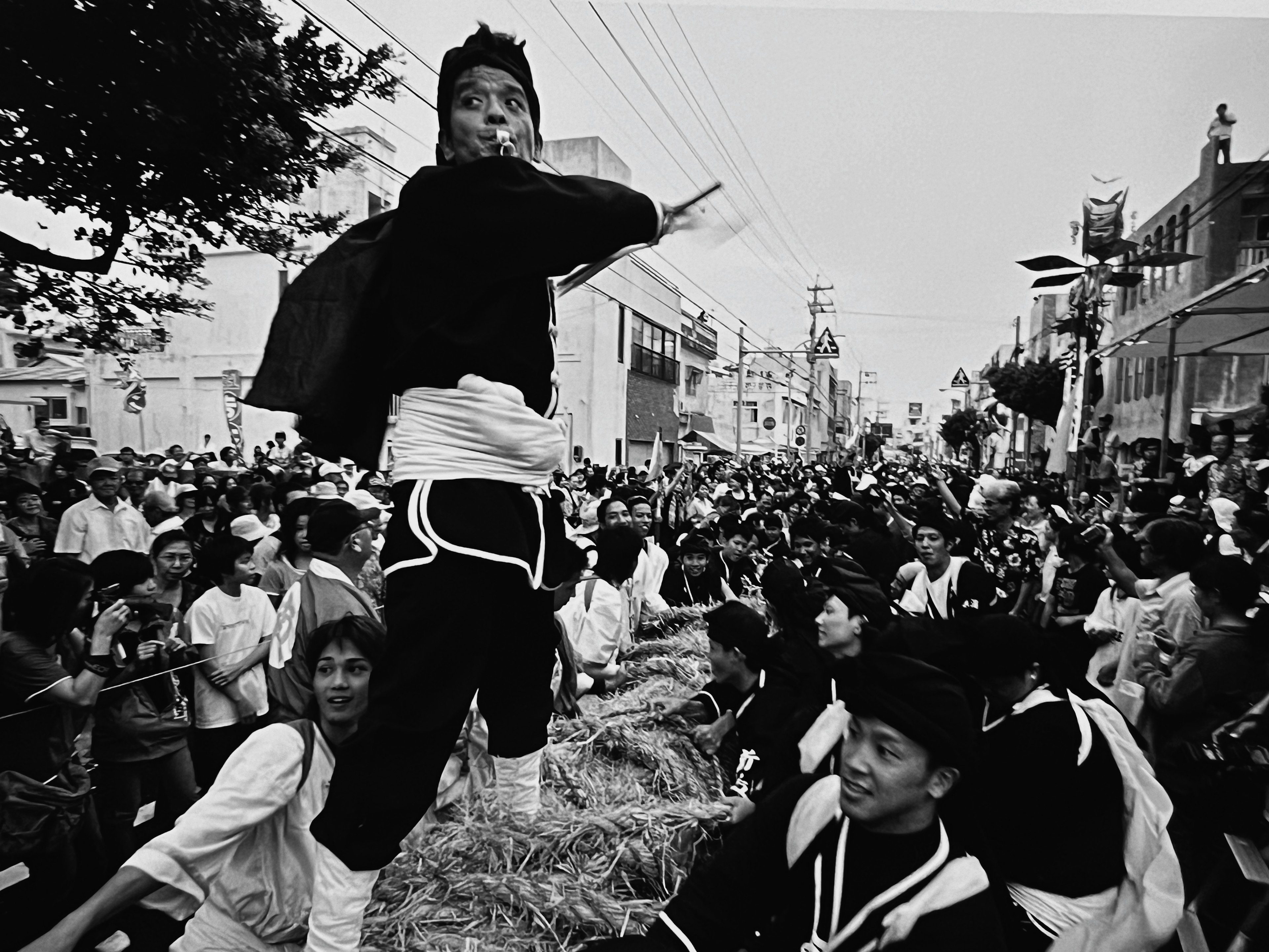 Photo en noir et blanc de participants à un festival dansant en tenue traditionnelle