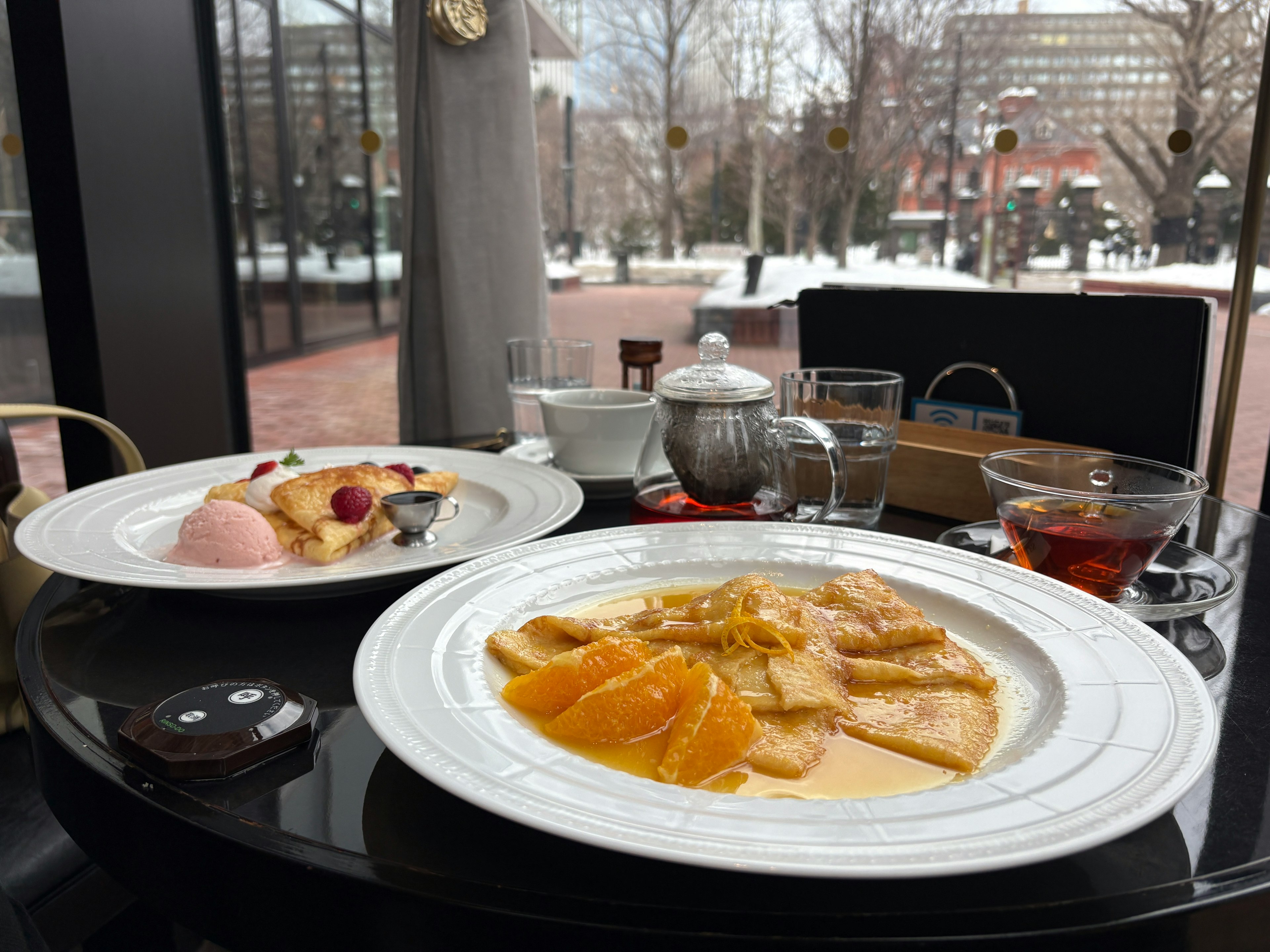 Una mesa de desayuno bellamente dispuesta con un plato de naranjas y frutas variadas