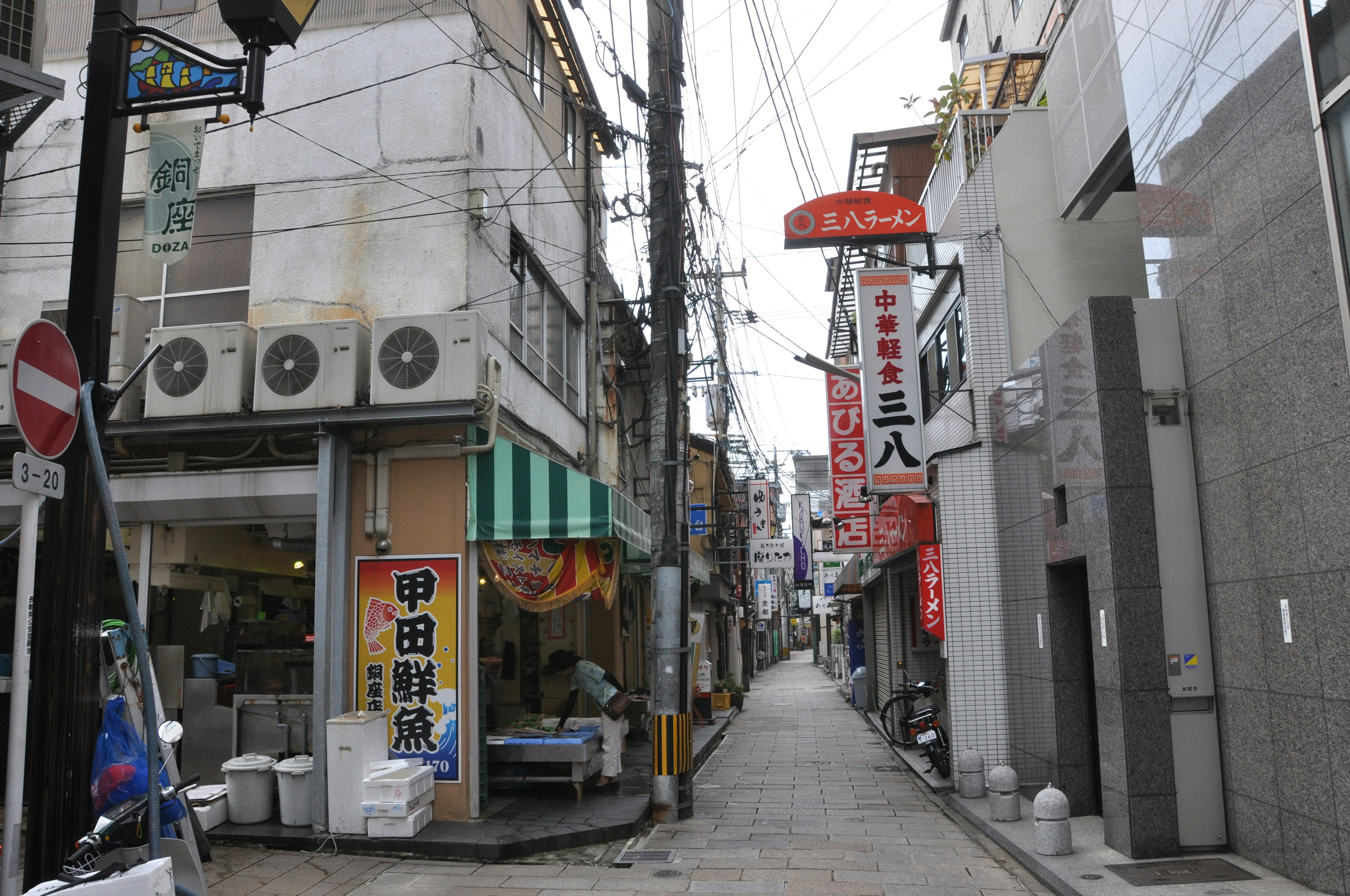 Narrow alley lined with shops and signs