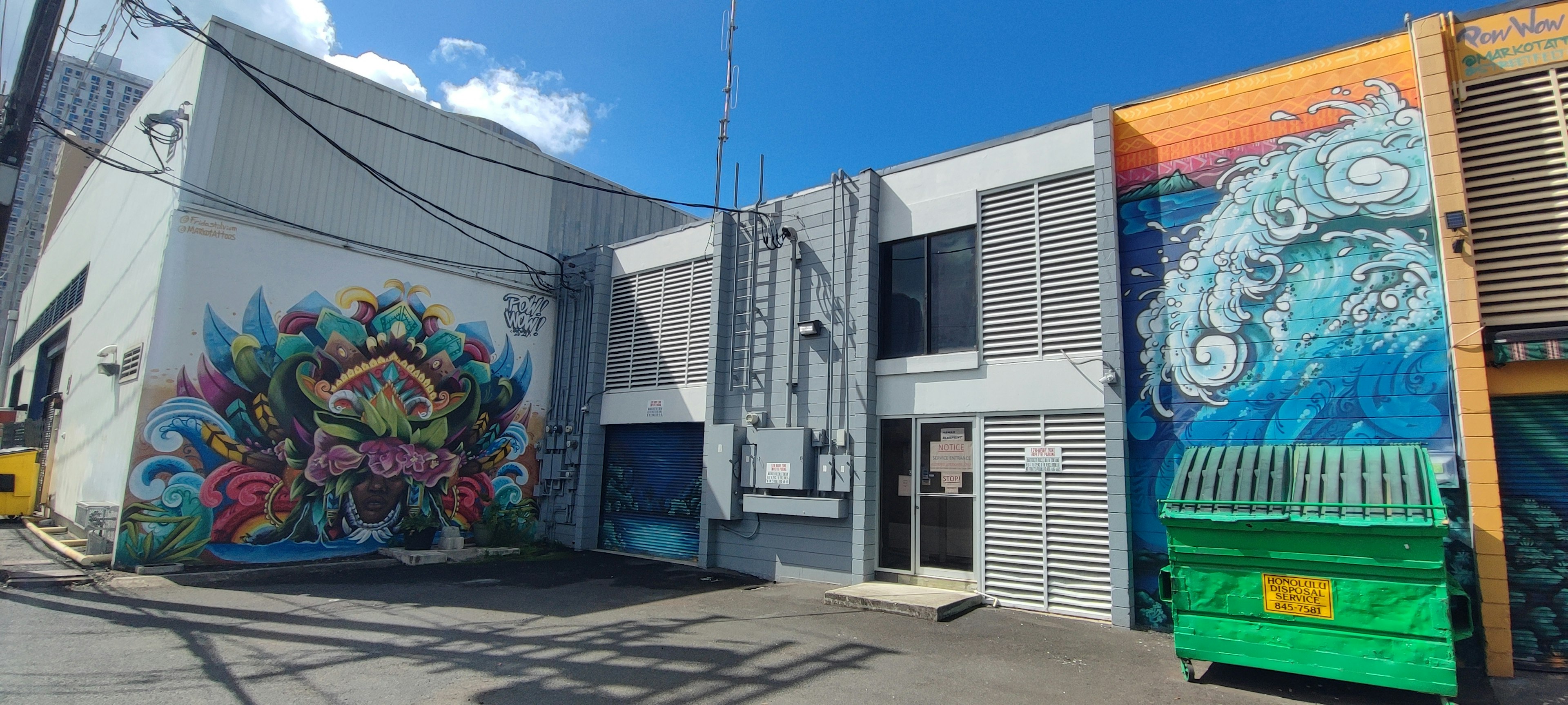 Exterior of a building featuring colorful murals and blue sky