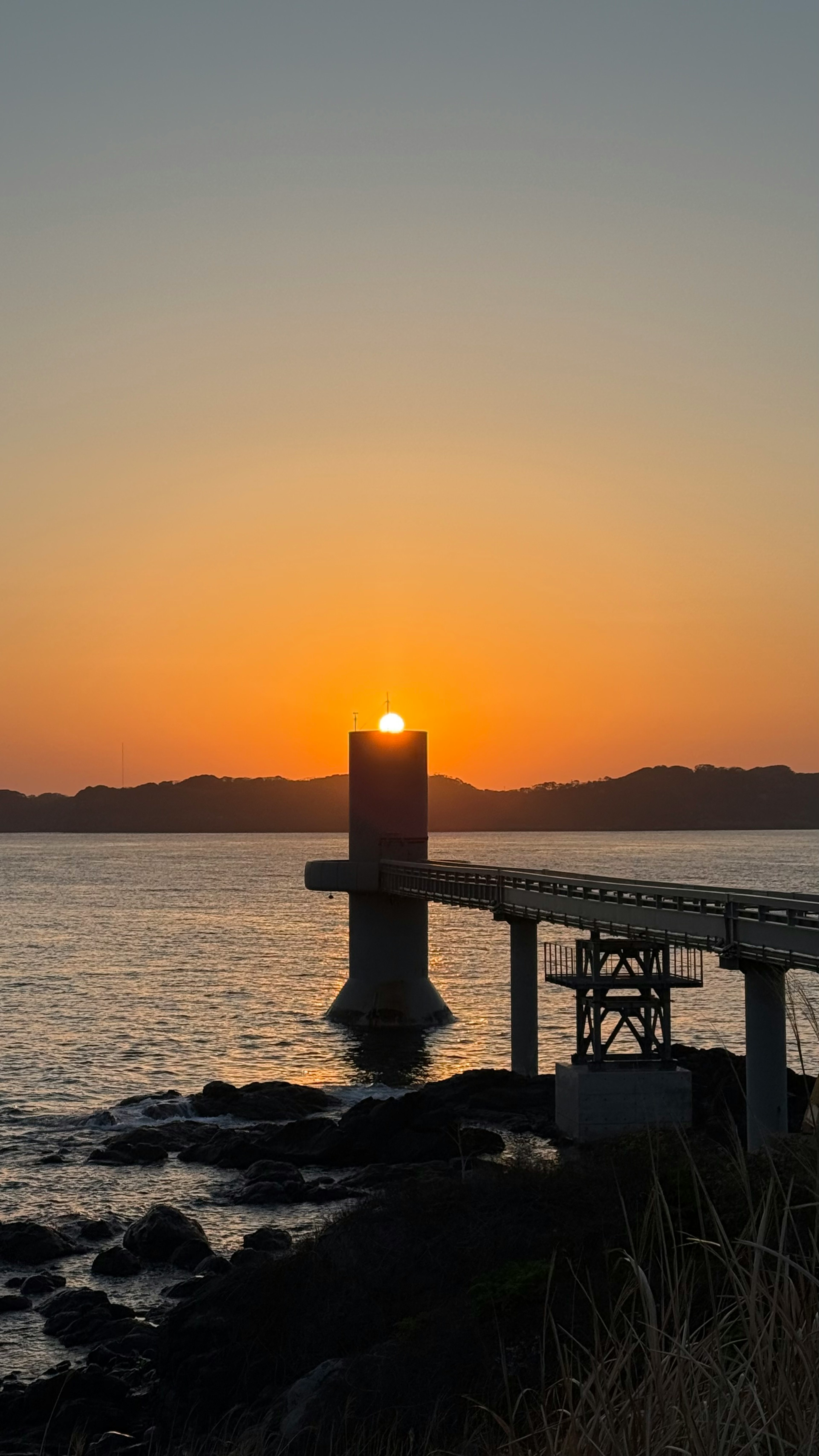 Vista panoramica di un faro e di un tramonto sul mare