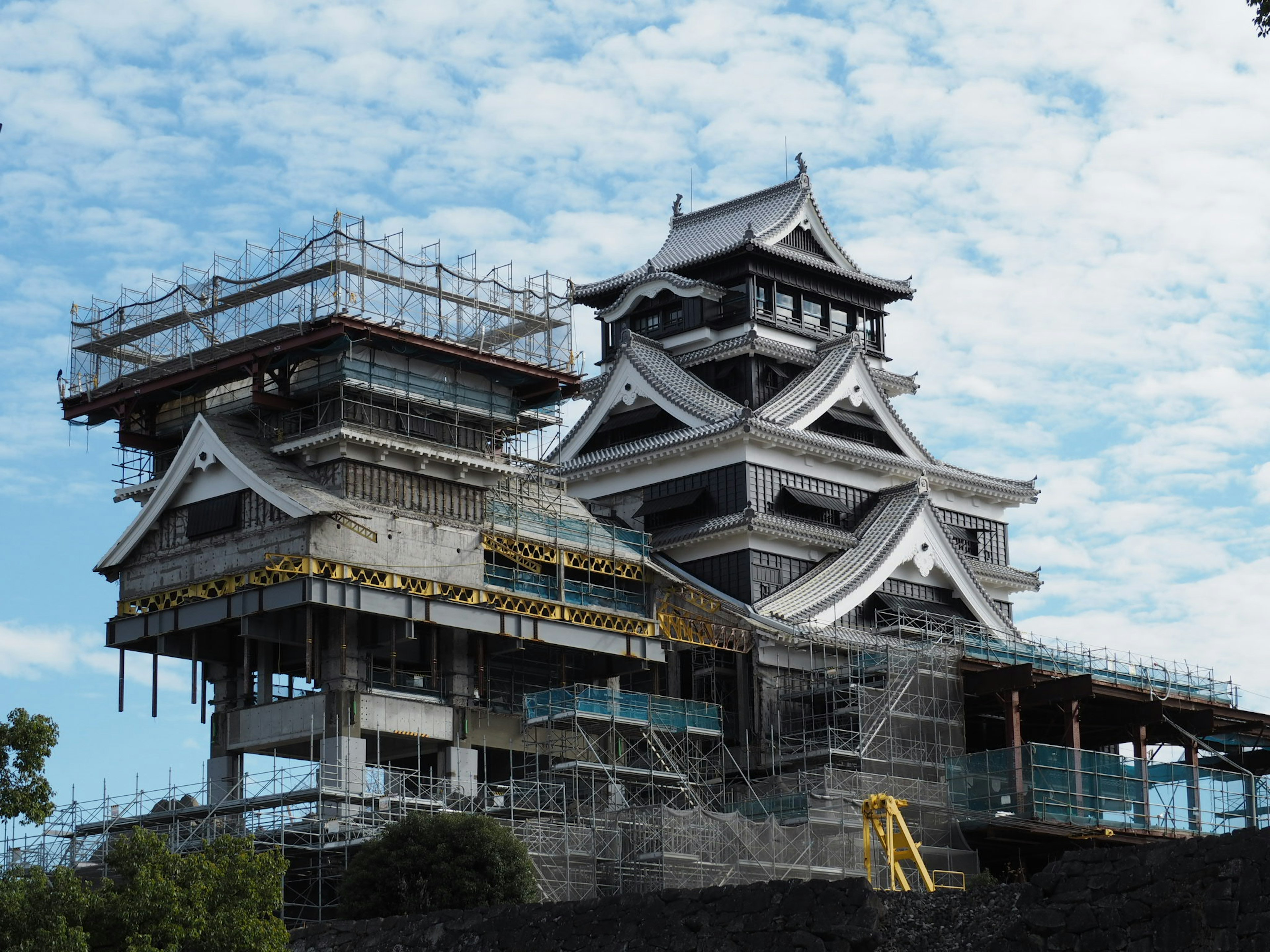 修復中の城の建物で、白い屋根とスカフォールディングが見える