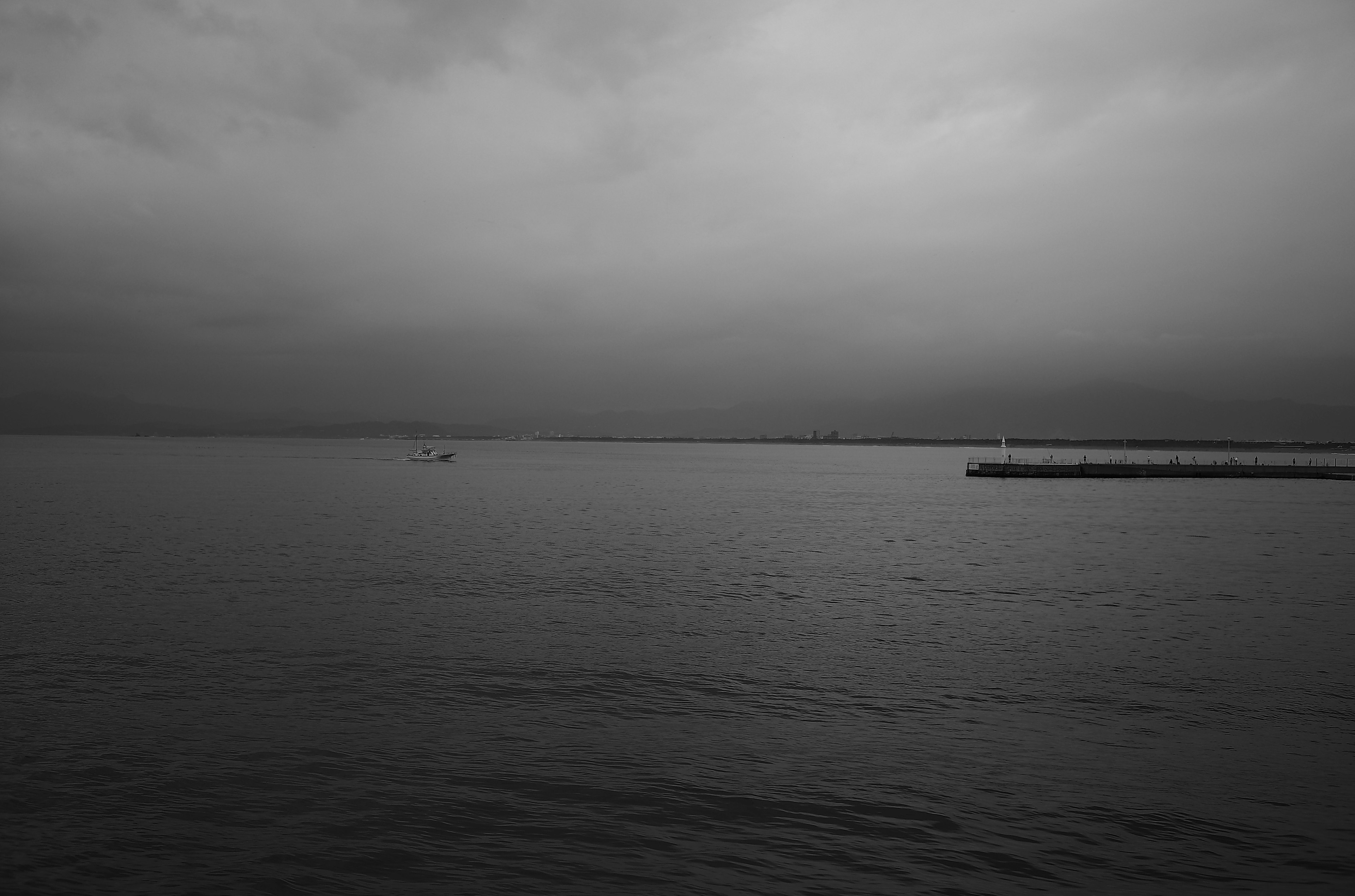 暗い雲に覆われた海の景色と静かな水面