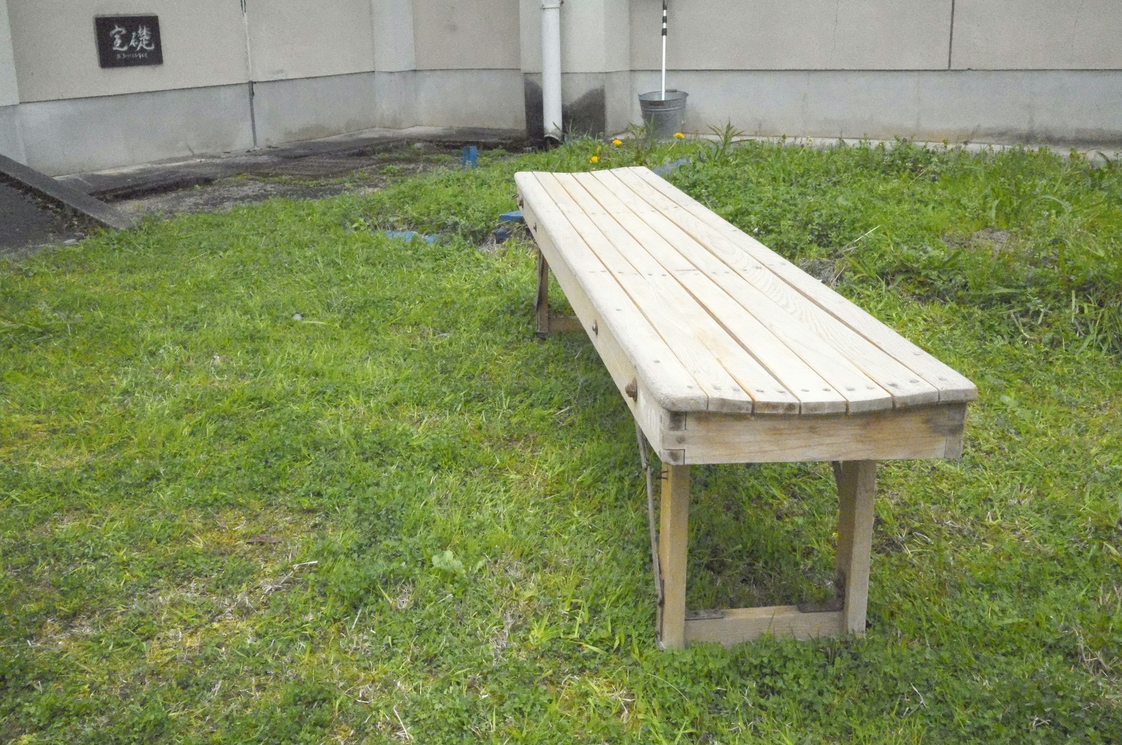 Banc en bois entouré d'herbe