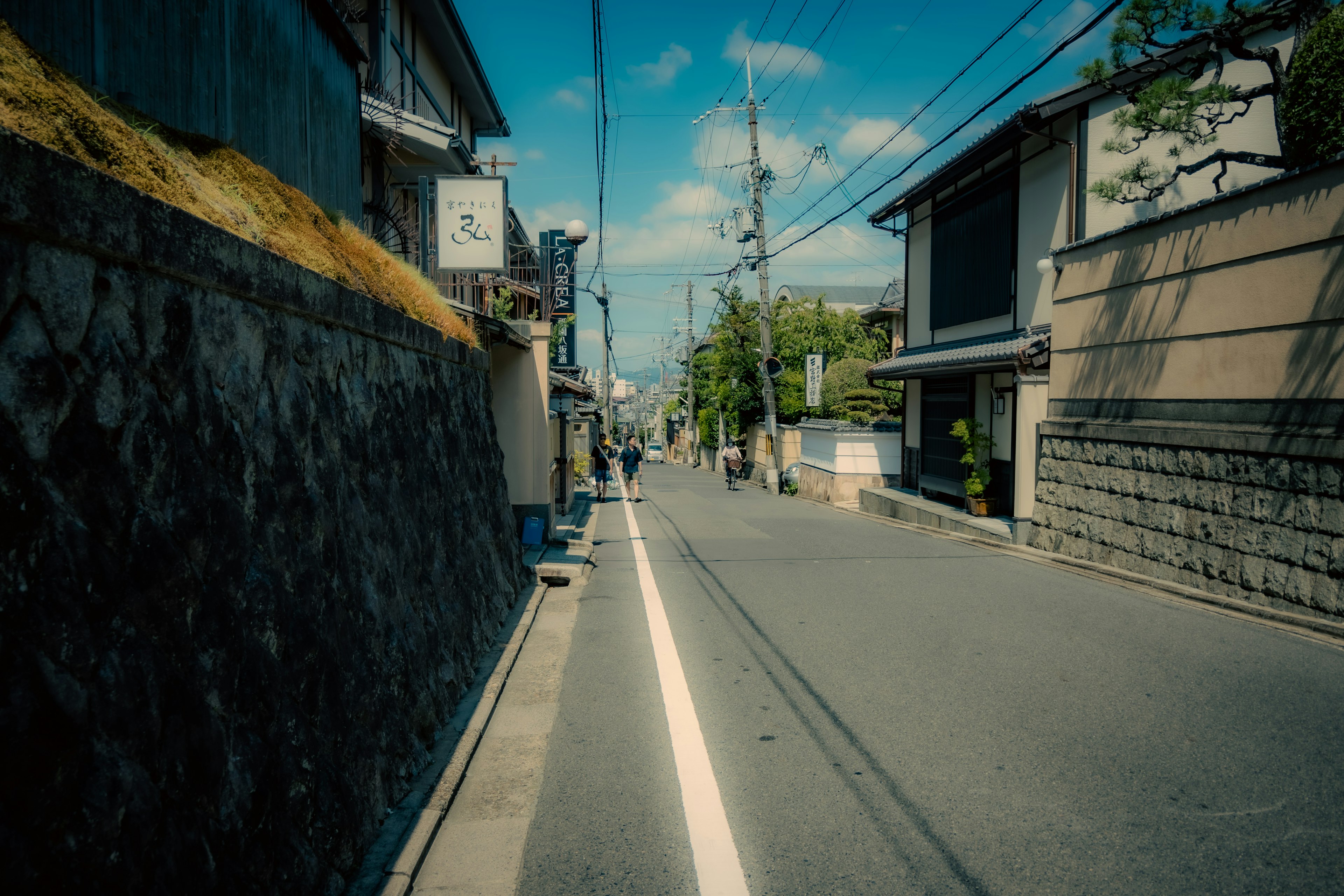 Schmale Straßenszene in einem japanischen Wohngebiet mit blauem Himmel