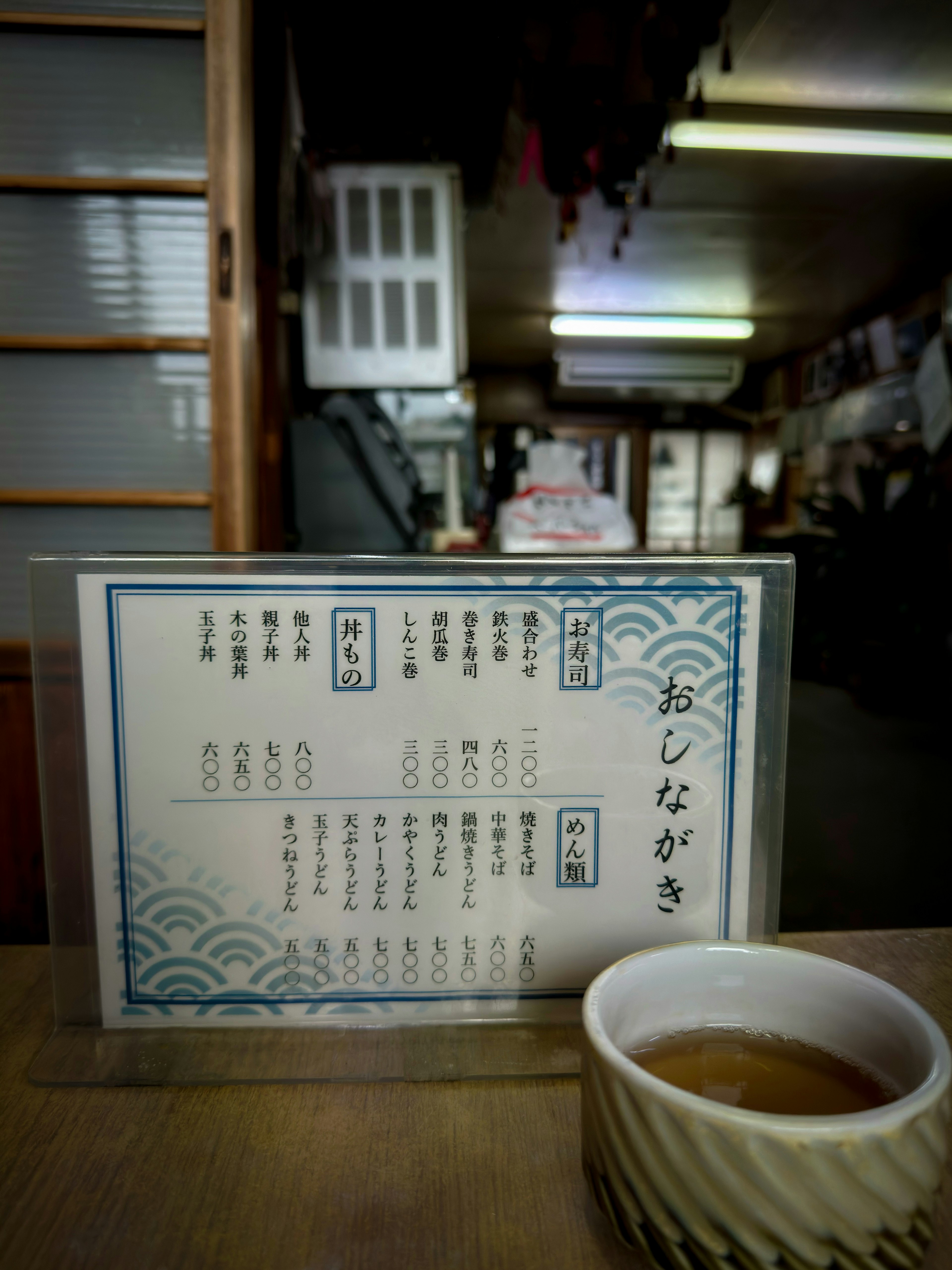 Table with a menu and a tea cup in a Japanese restaurant interior