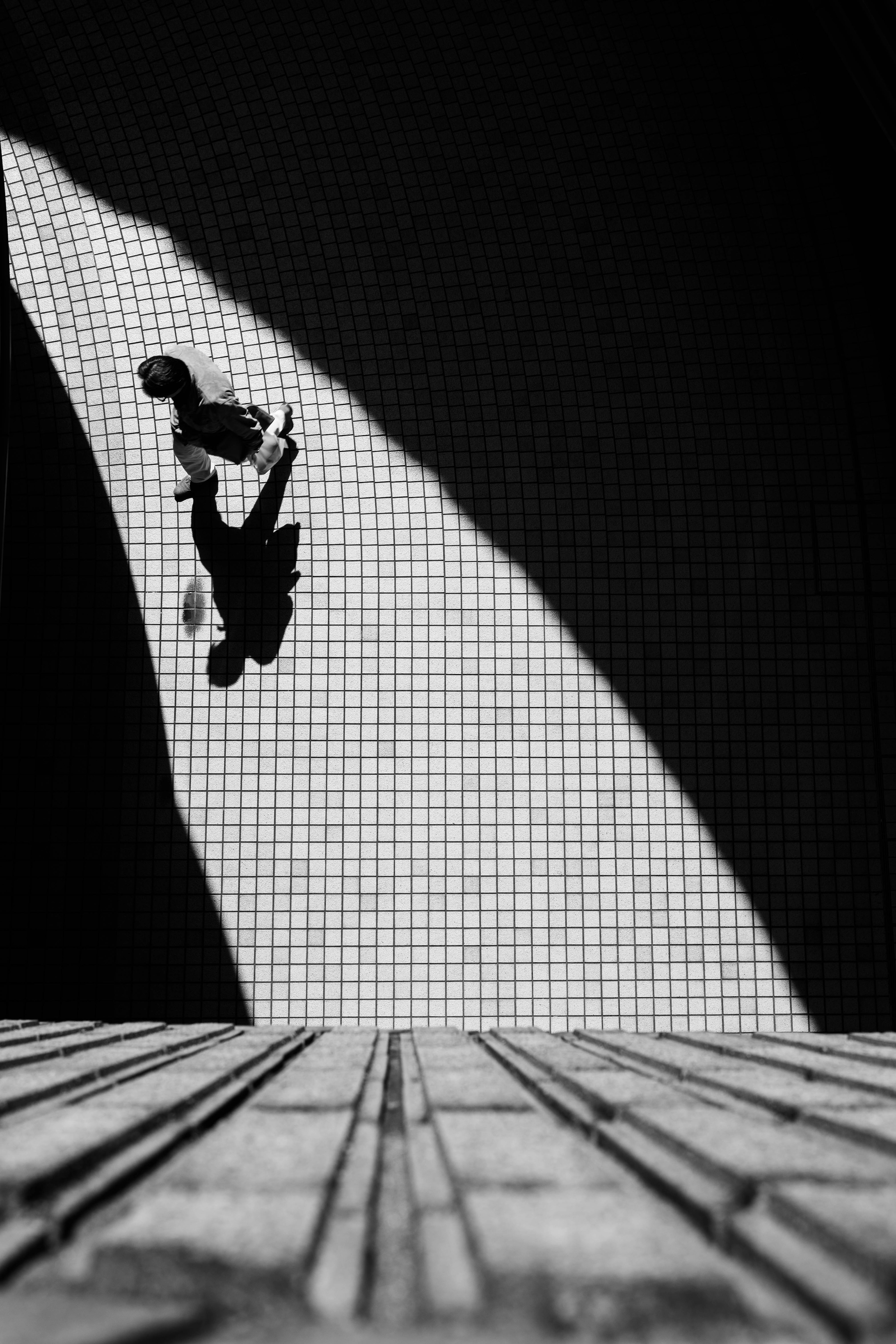 Silhouette of a person against a curved black and white background