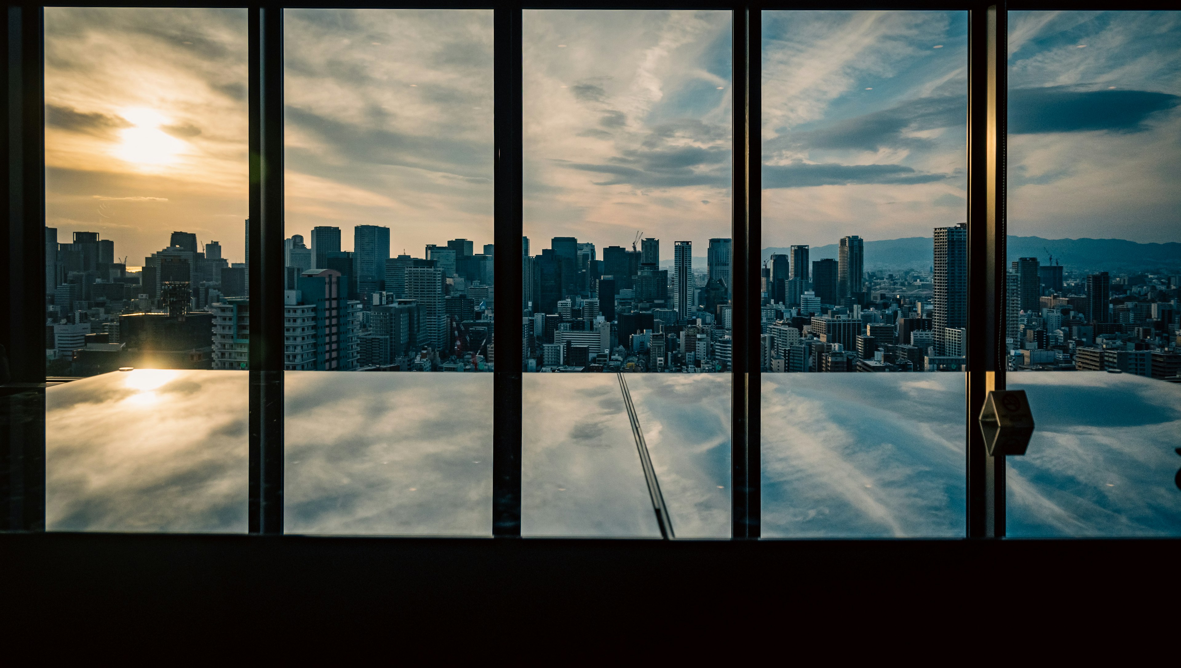 Panoramic city view with sunset reflected in glass windows