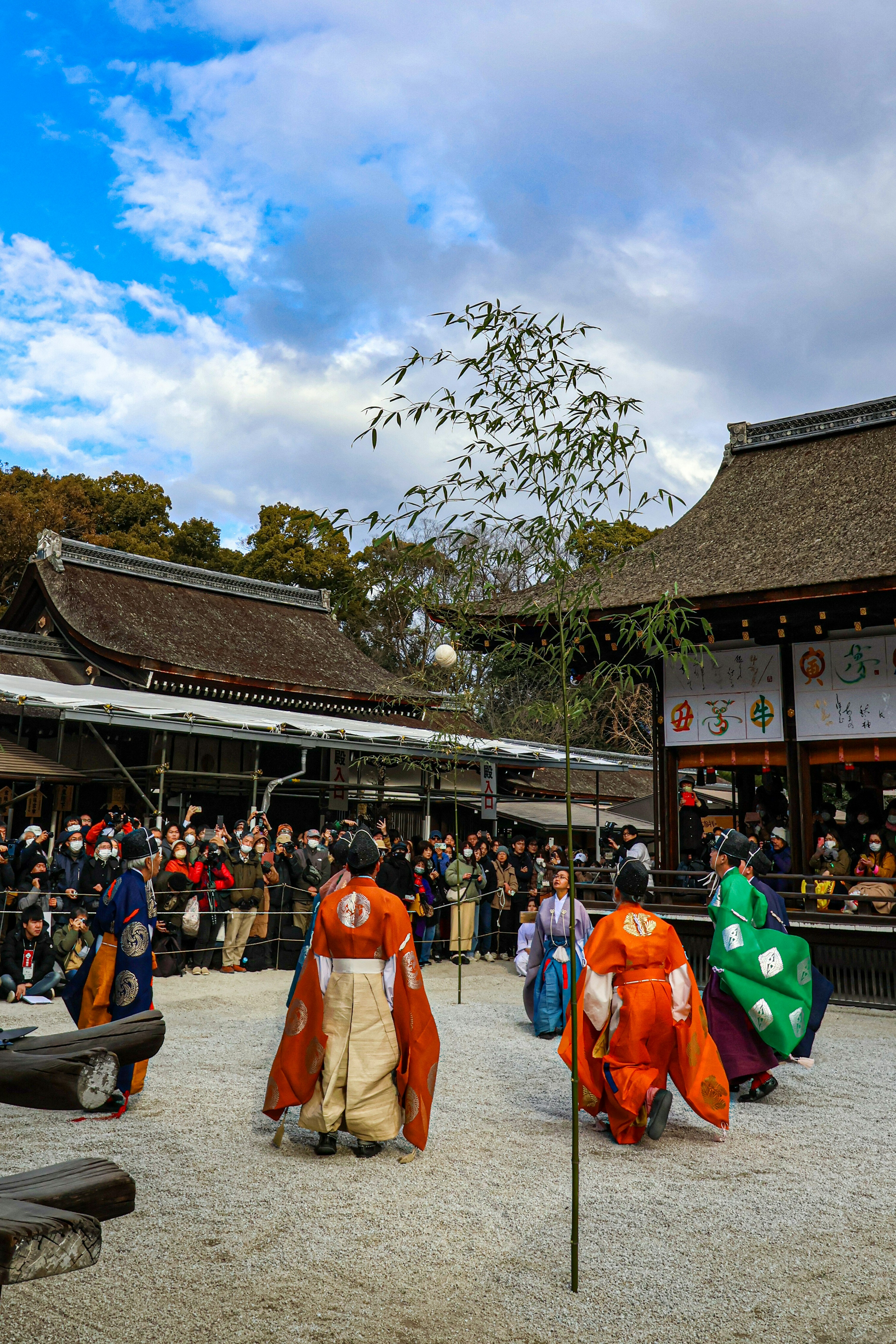 Festival tradisional Jepang dengan penari berpakaian warna-warni di halaman yang dikelilingi penonton