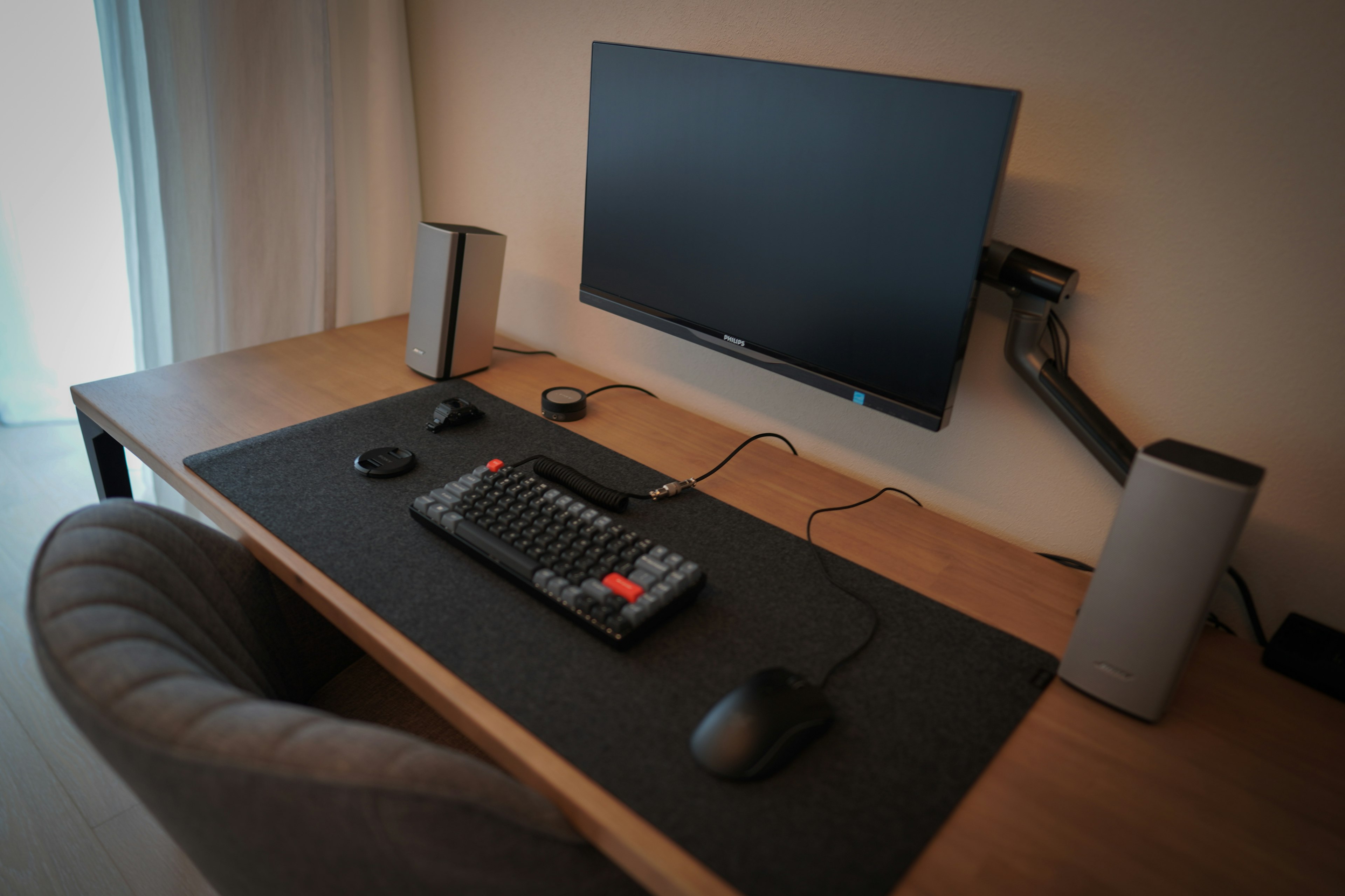 Minimalistic desk setup featuring a monitor keyboard and speakers