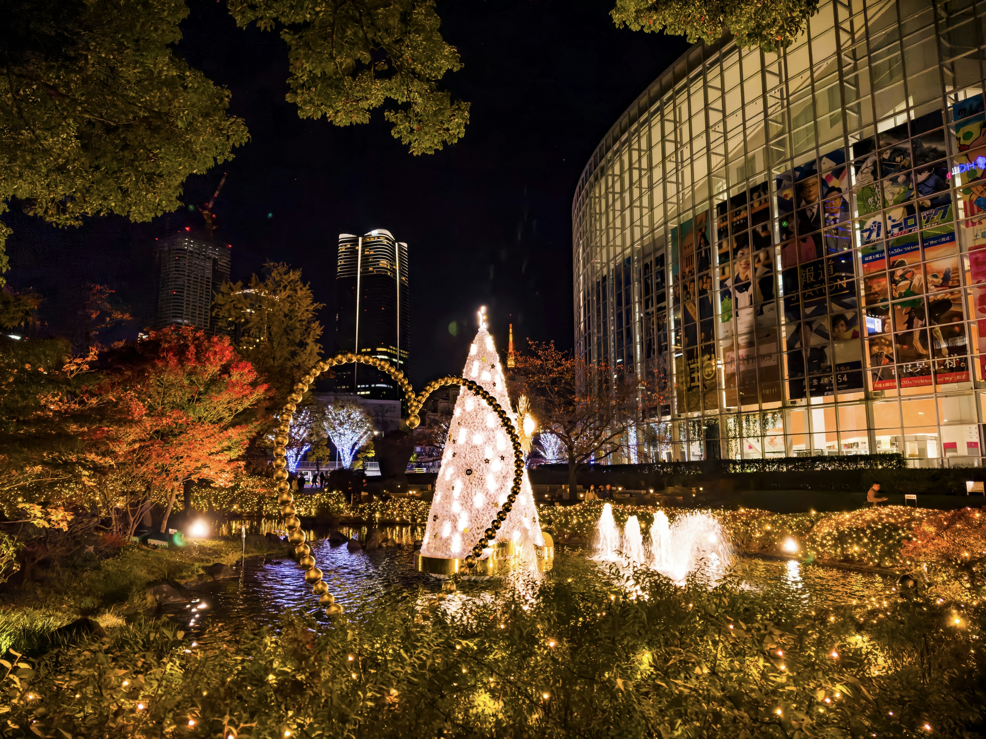 Beleuchteter Weihnachtsbaum und herzförmige Dekorationen in einem Nachtpark