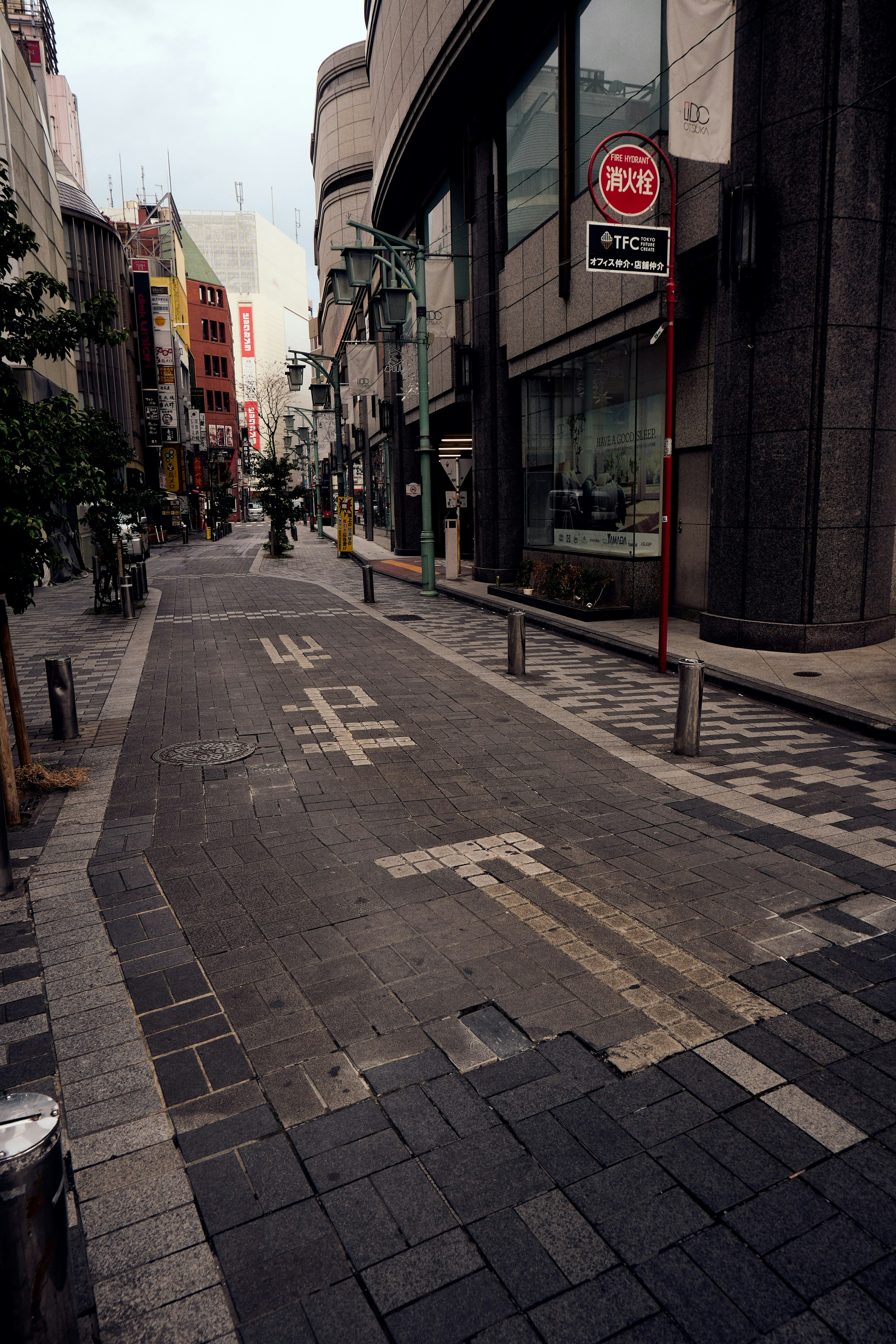 Narrow street featuring buildings and paved sidewalk