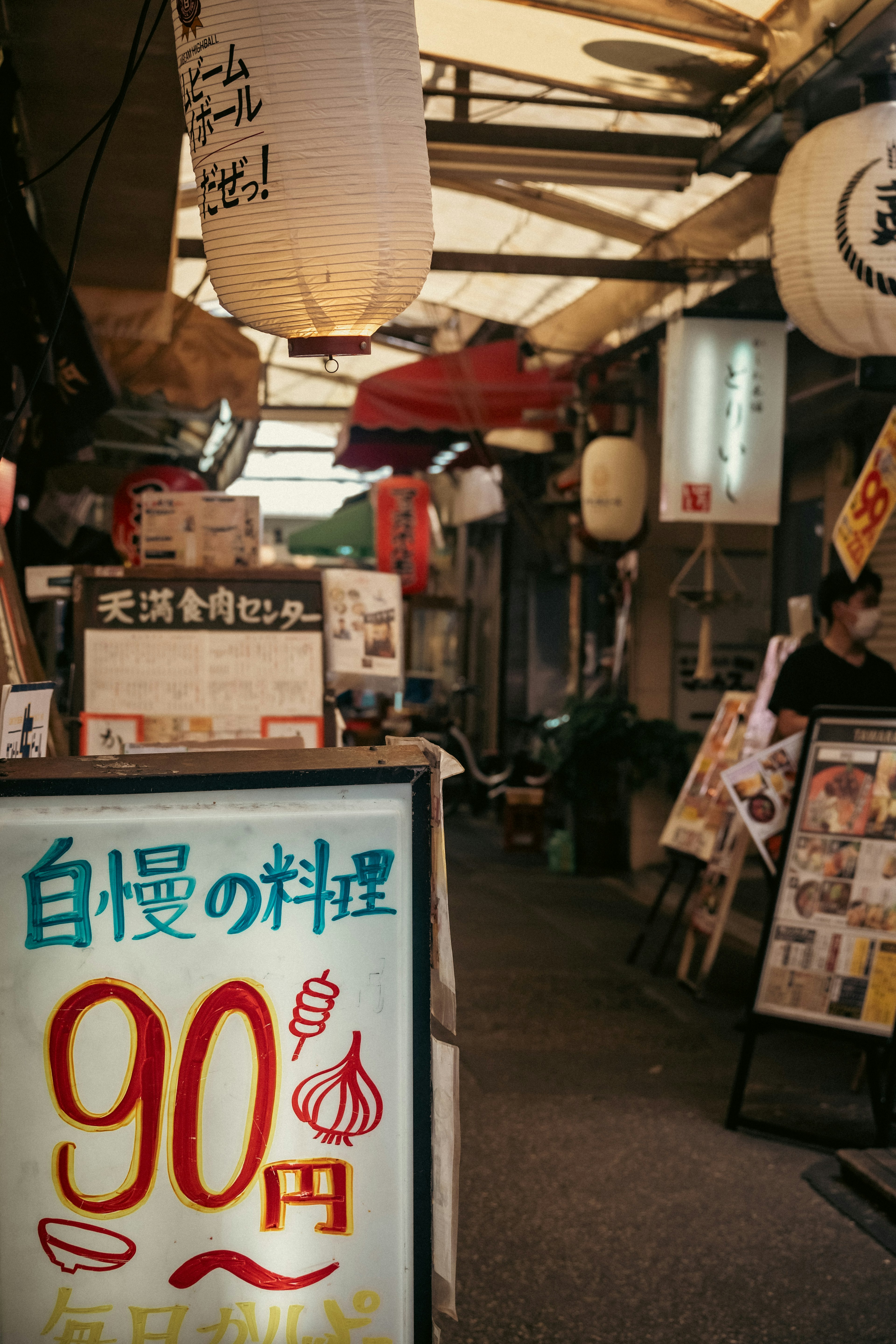 Narrow street scene with restaurant sign and lanterns