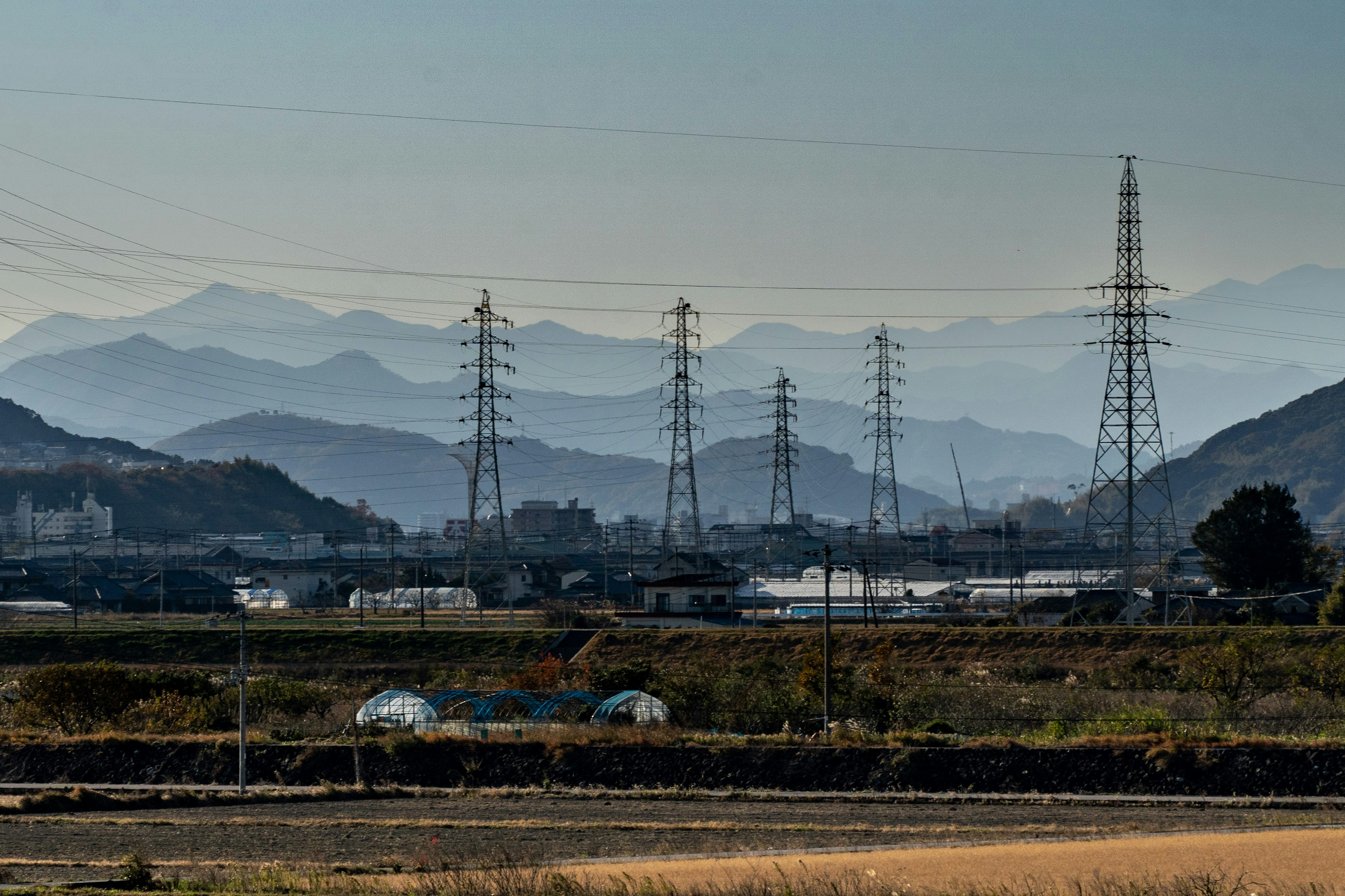 Paisaje con líneas eléctricas frente a un fondo montañoso