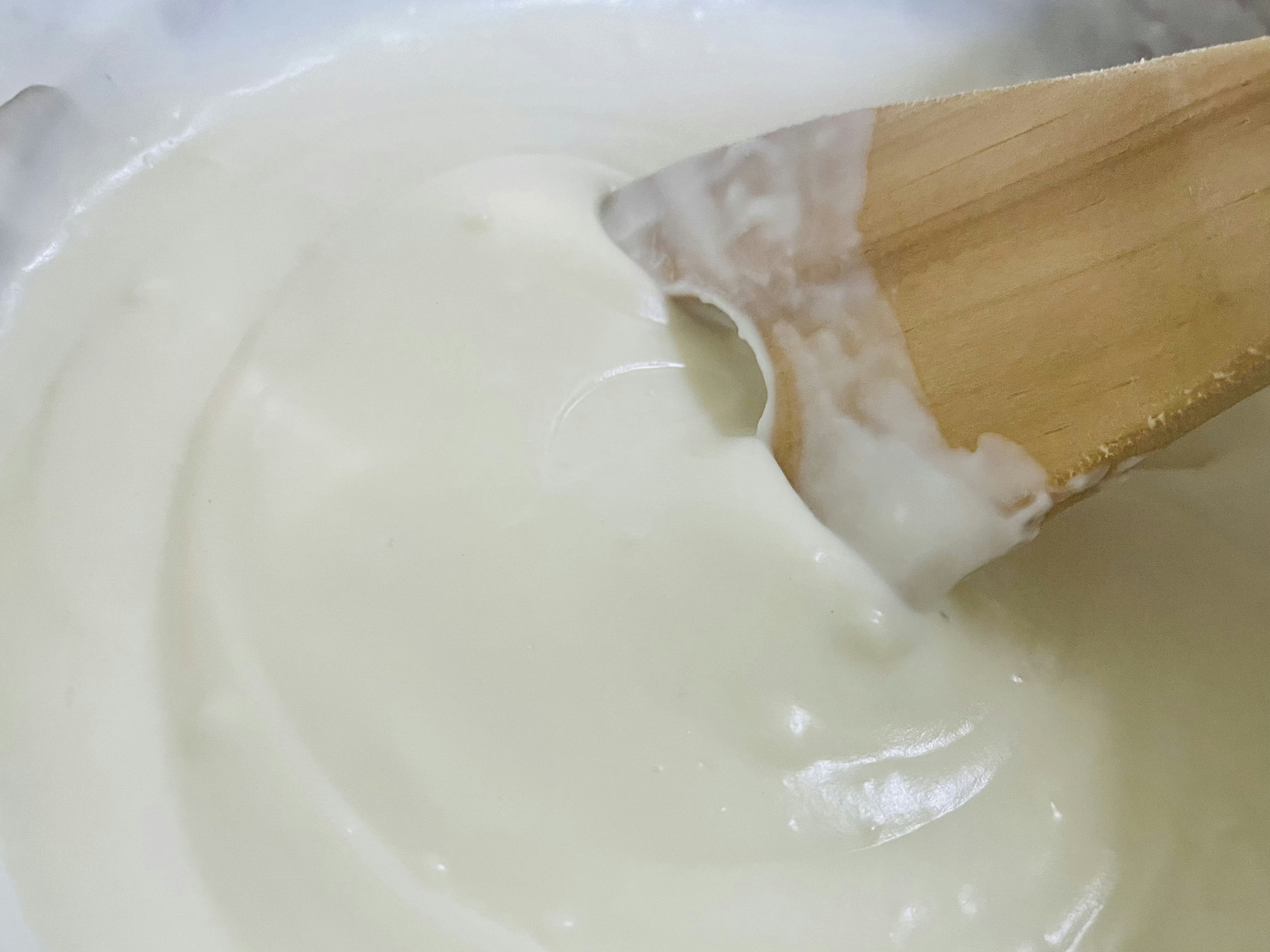 Creamy batter with a wooden spoon stirring