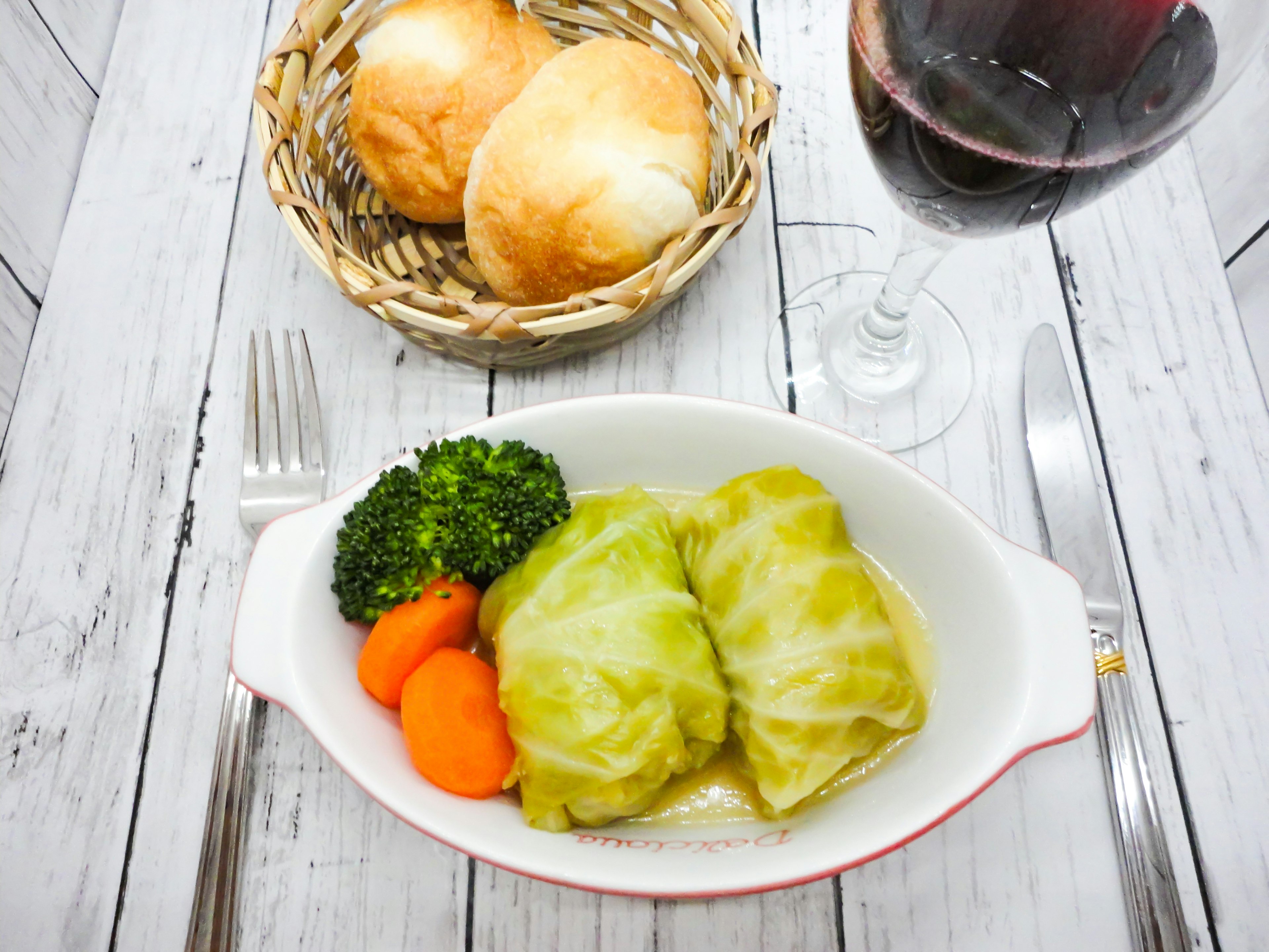 Rouleaux de chou servis avec du brocoli et des carottes dans un panier de pain