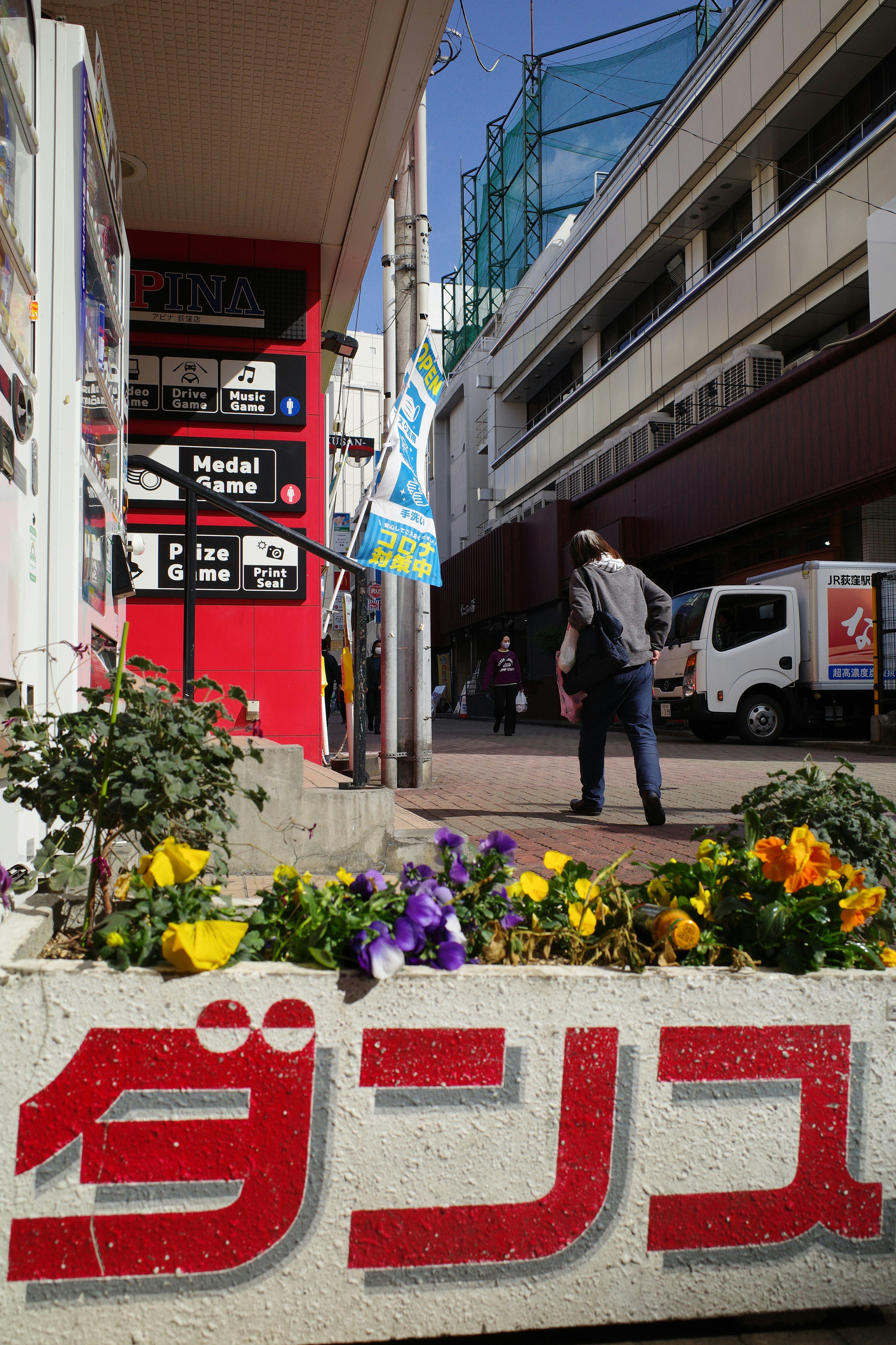 赤い看板と花が咲く街角の風景