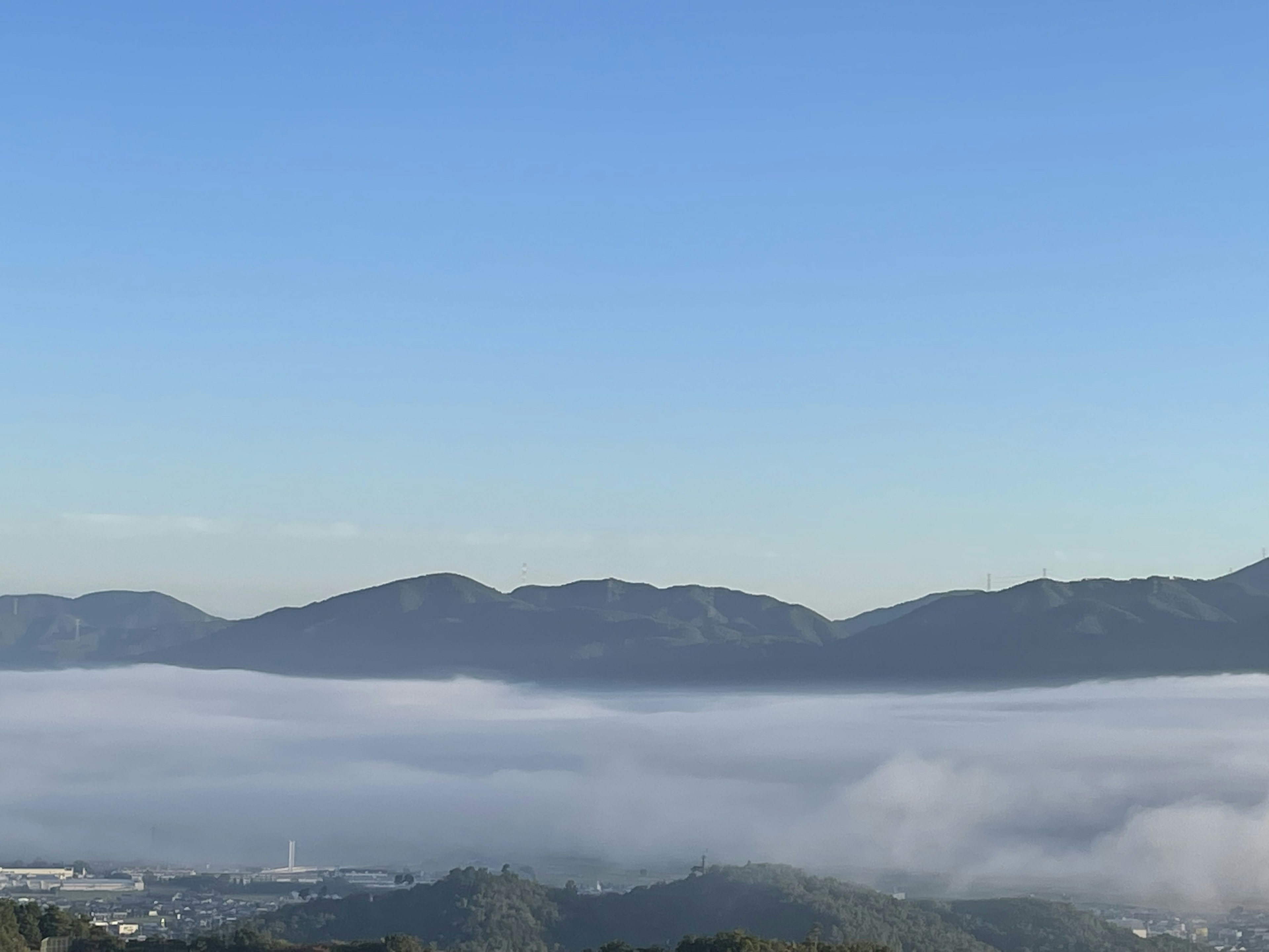 Landscape featuring mountains and a sea of clouds under a blue sky