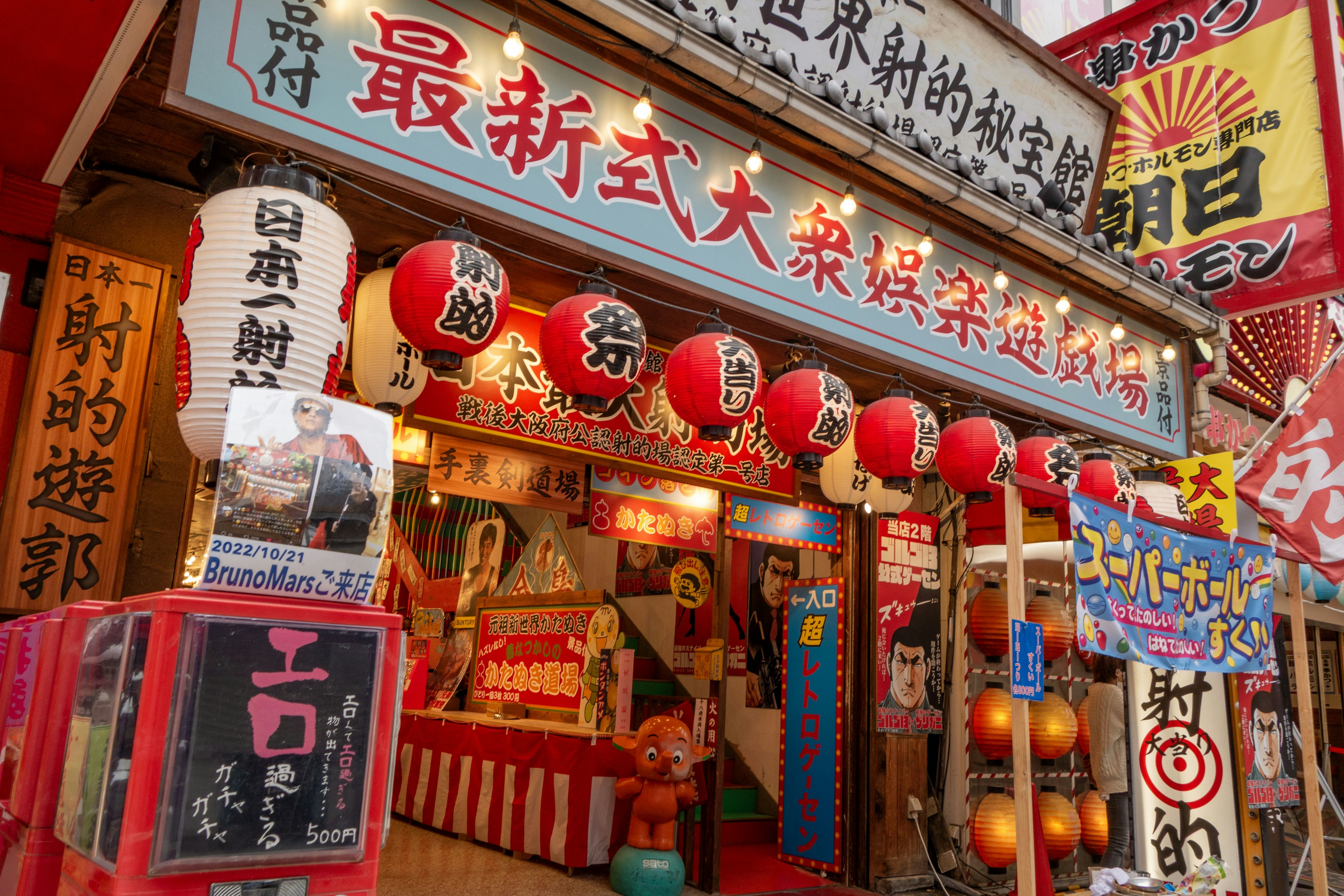 Extérieur d'un restaurant japonais traditionnel décoré de lanternes rouges et de panneaux colorés