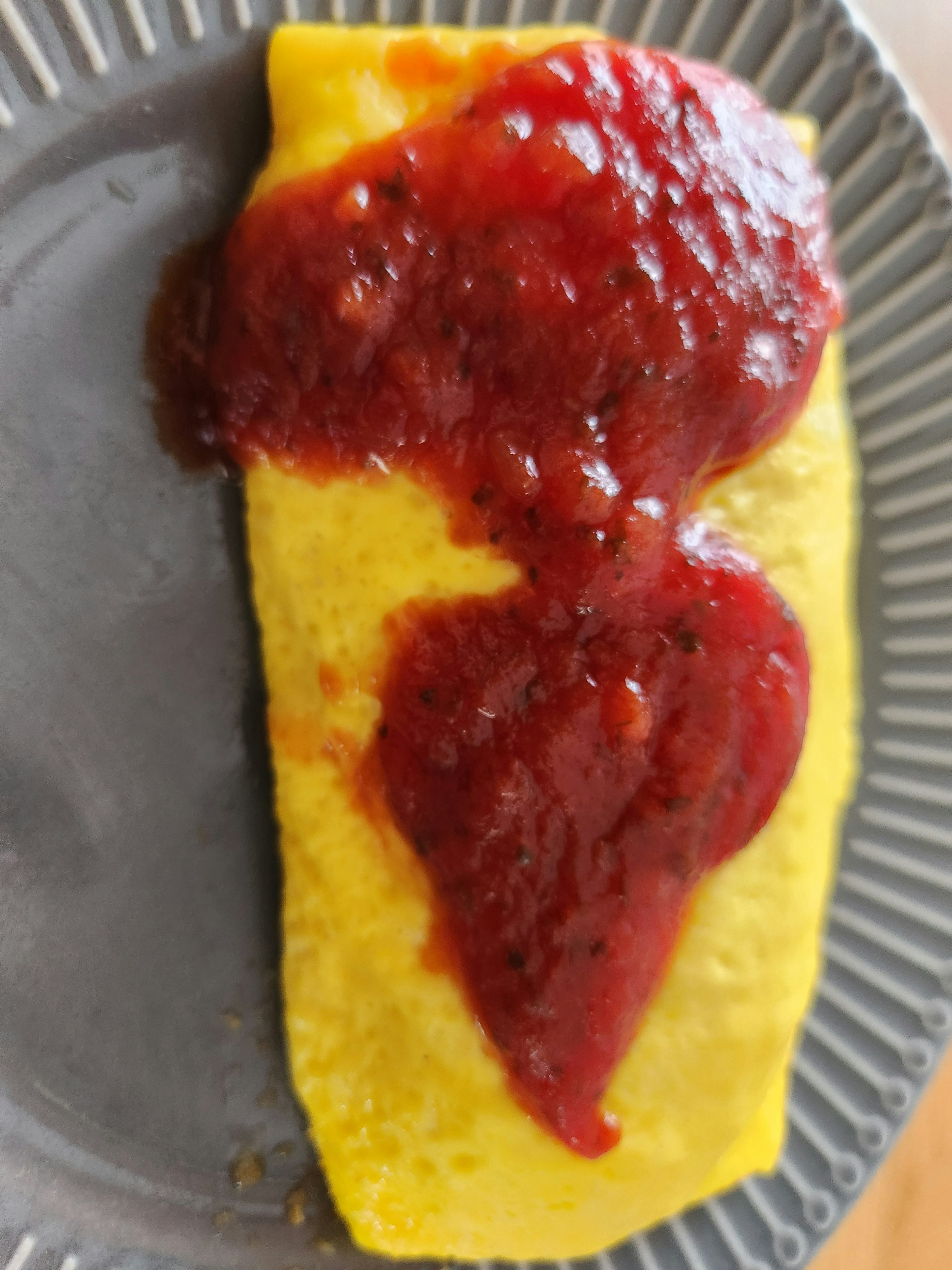 Omelet amarillo cubierto con salsa roja