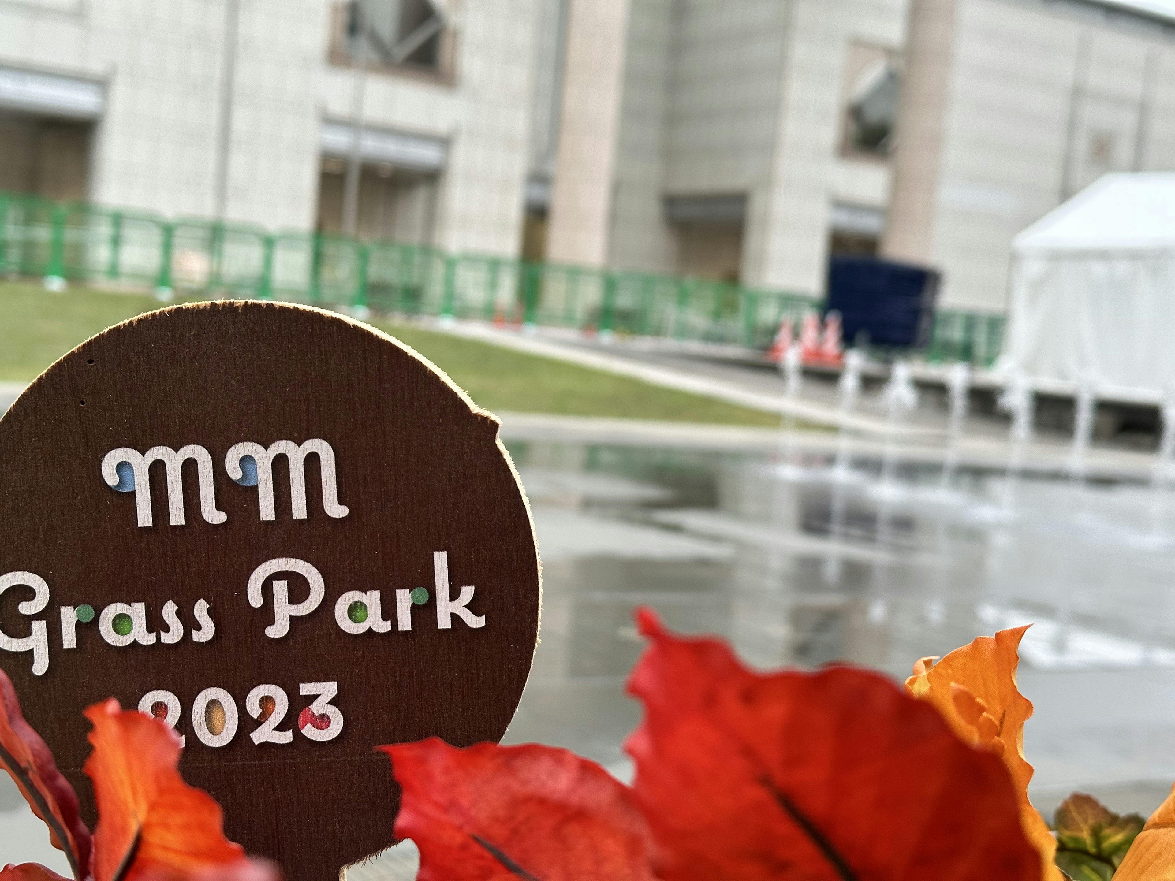 Schild für MM Grass Park 2023 mit Herbstblättern im Vordergrund