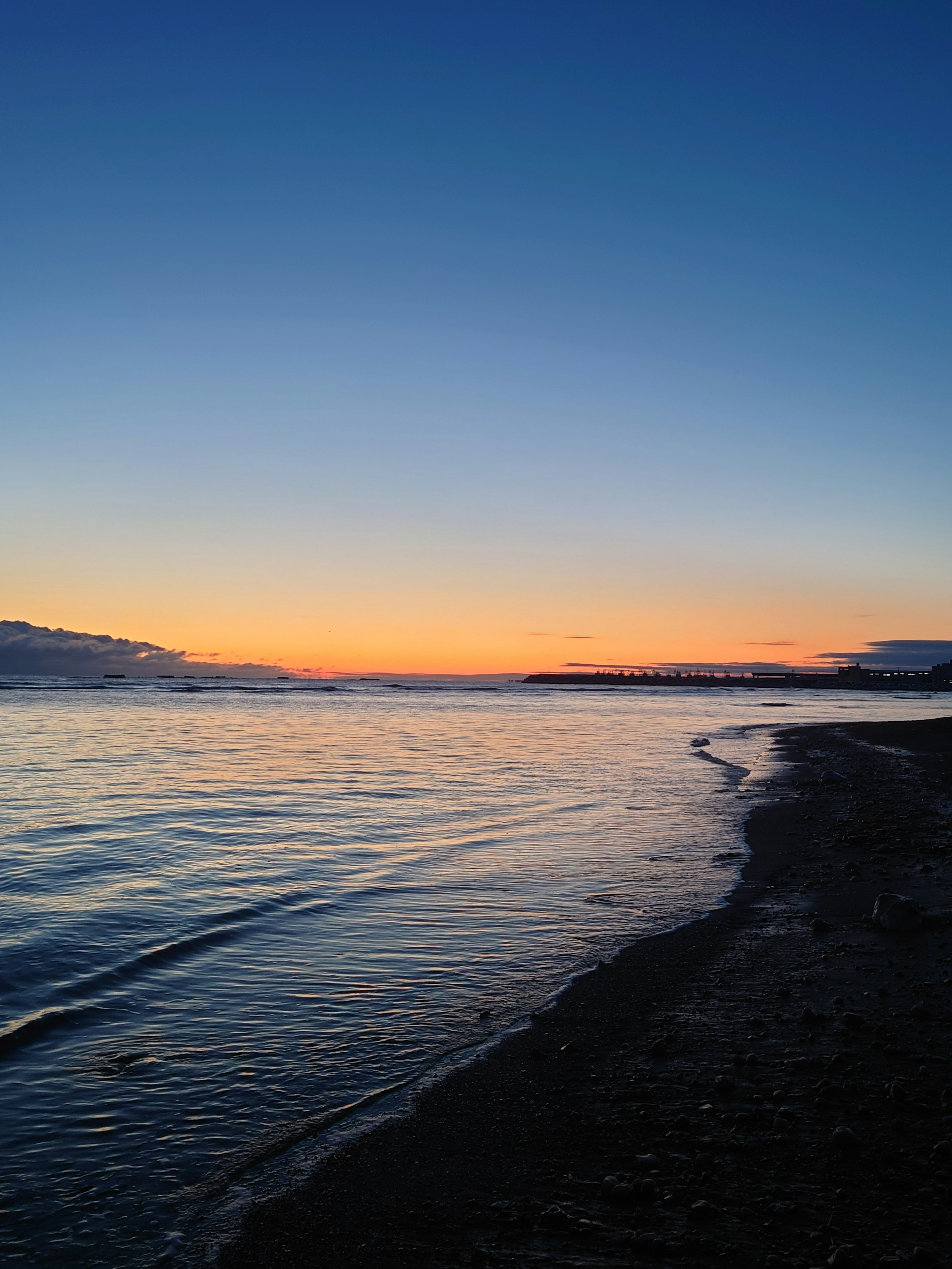 Coucher de soleil côtier avec surface d'eau calme