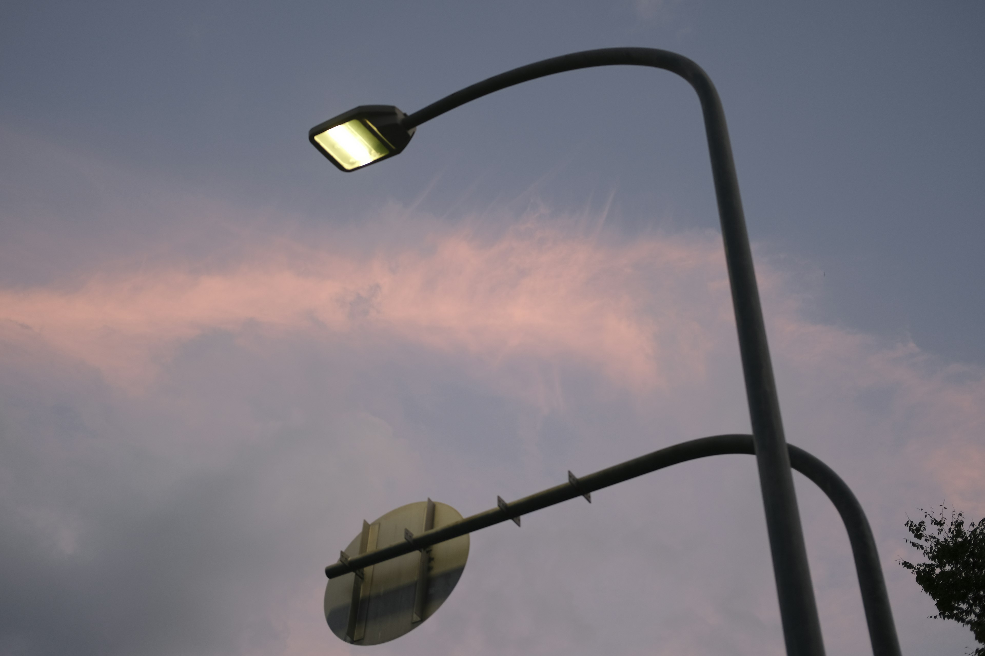 Streetlight and sign against a twilight sky