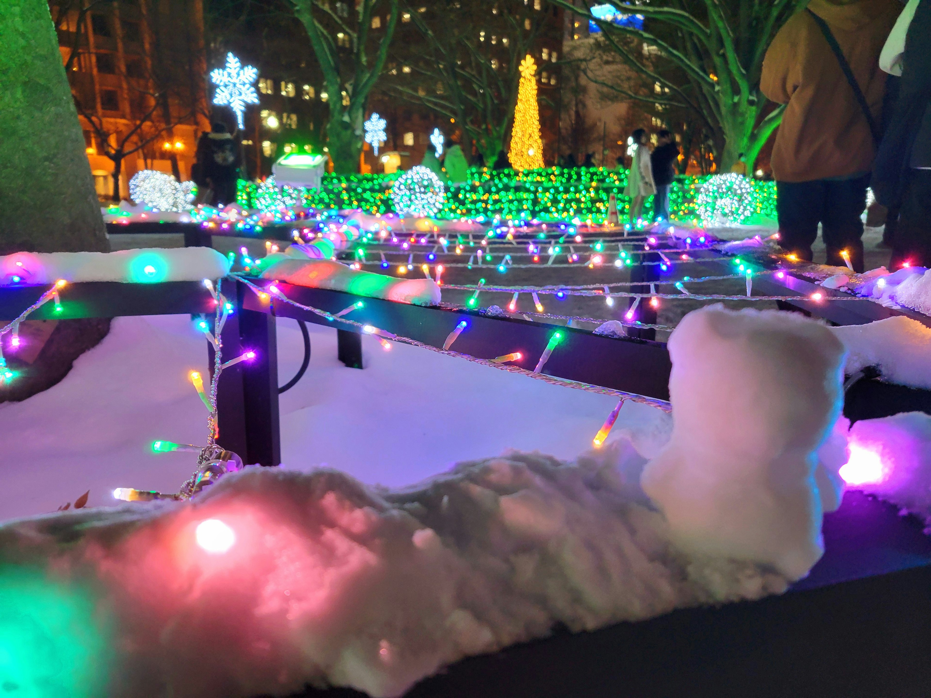 Luces coloridas brillando en el suelo cubierto de nieve en una escena invernal