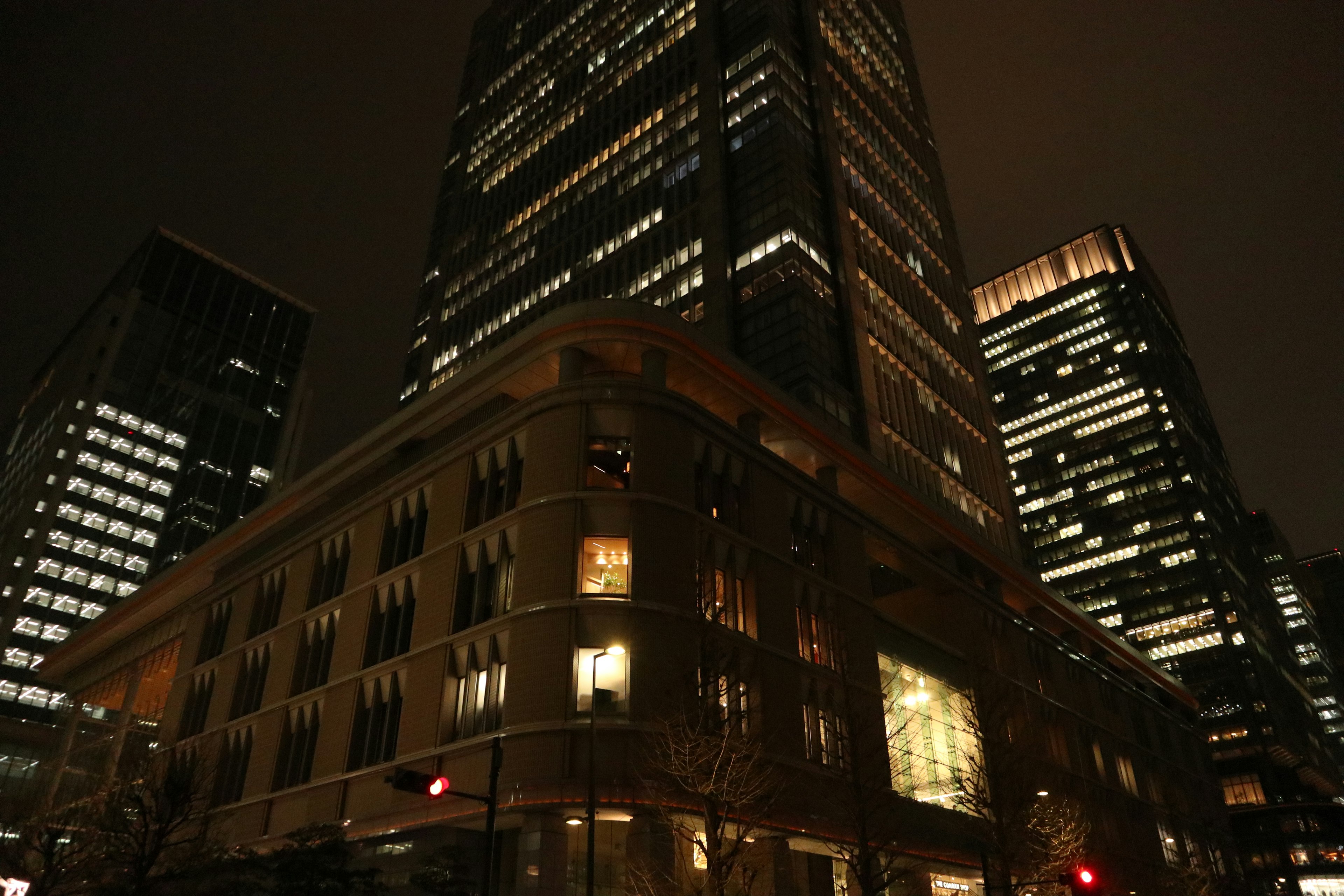 Nighttime cityscape featuring tall buildings and a historic structure