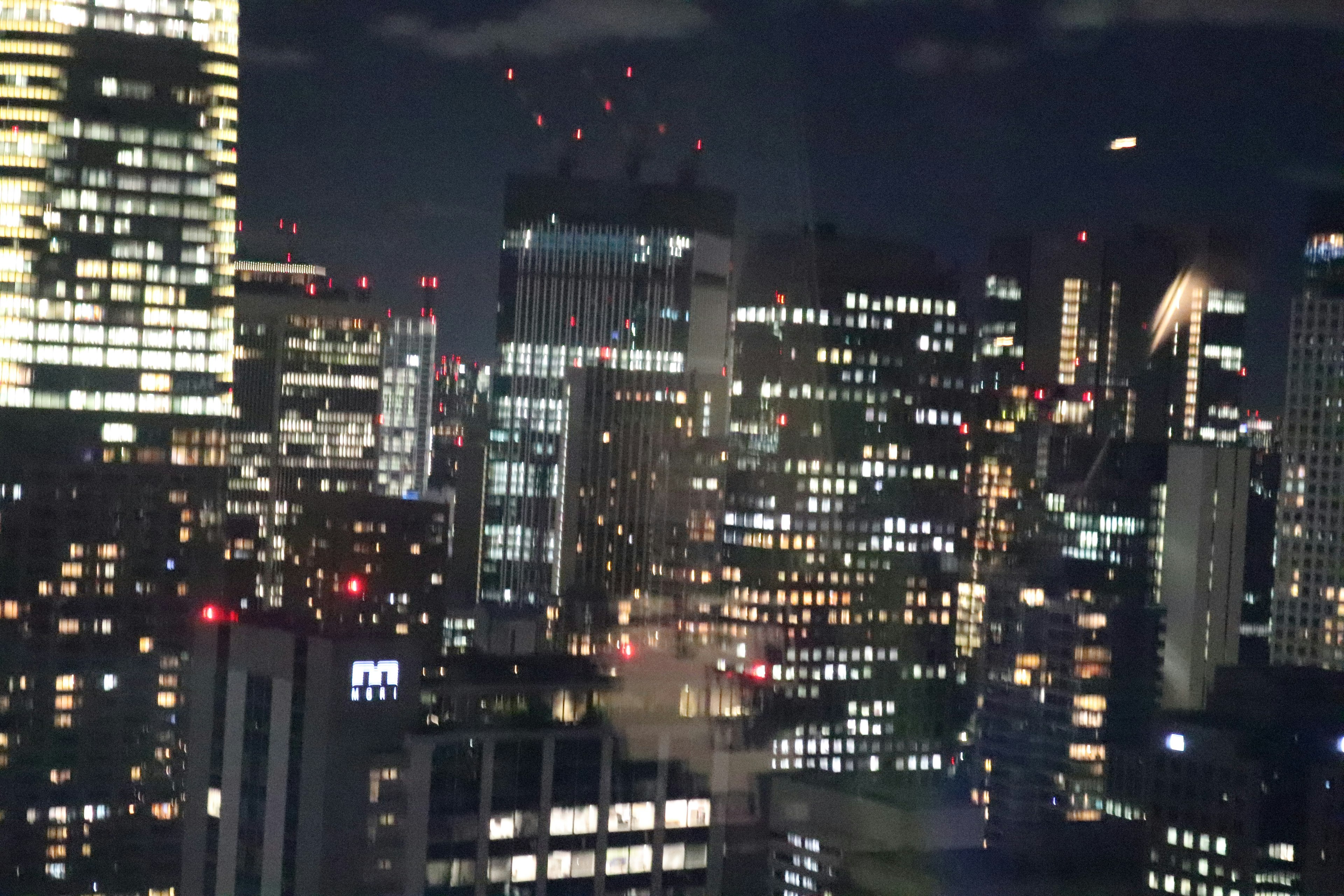 Beleuchtete Wolkenkratzer in einer Stadt bei Nacht